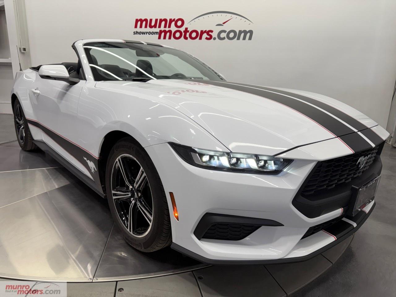 Vehicle Highlights include: Premium, Black Power Convertible Soft Top, 201A, Ford Co-Pilot 360 Assist+, Navigation, Satin Black Race Over the Top Race Stripes, 18 Inch Machined Aluminum Wheels, B&O Sound System, Active Exhaust System, Mini Spare Wheel, Adaptive Cruise Control, Lane Keeping, BLIS, Ambient Lighting, Apple Carplay, Android Auto, & Carpet Floor Mats. <br /><br /> The 2024 Ford Mustang EcoBoost Premium Convertible represents a bold evolution of Americas iconic pony car. Blending turbocharged performance, premium comfort, and unmistakable styling, this latest-generation Mustang delivers an engaging driving experience with the added thrill of top-down freedom. Whether cruising city streets or carving through winding highways, the EcoBoost Premium Convertible proves that performance and sophistication can coexist in one exciting package. <br /><br /> Ford redesigned the 2024 Mustang with sharper lines, a more aggressive stance, and aerodynamic enhancements that give the EcoBoost Premium Convertible a commanding presence. The signature LED tri-bar lighting, sculpted hood, and wide grille create a look that is unmistakably Mustang while embracing a more contemporary aesthetic. <br /><br /> The power-operated soft top folds down quickly, transforming the vehicle from a sleek coupe-inspired silhouette into an open-air touring machine. Available wheel designs, vibrant exterior colors, and black accent packages allow drivers to personalize the Mustang to match their personality. <br /><br /> Inside, the cabin combines sporty character with upscale materials. Leather-trimmed seating, ambient lighting, and premium accents elevate the driving experience, while the driver-focused cockpit keeps every control within easy reach. <br /><br /> Under the hood, the 2024 Mustang EcoBoost Premium Convertible features a 2.3L turbocharged EcoBoost engine that produces an impressive 315 horsepower while maintaining strong fuel efficiency. Paired with a responsive 10-speed automatic transmission, the convertible delivers smooth acceleration and confident highway passing power. <br /><br /> Drivers can select multiple drive modes to tailor the cars personality, from relaxed cruising to sharper, sportier handling. Independent rear suspension and refined chassis tuning contribute to balanced cornering and a composed ride, making the Mustang equally enjoyable for daily commuting or weekend escapes. <br /><br /> The EcoBoost engine also offers a lighter front-end feel compared to V8 models, resulting in nimble handling characteristics that many driving enthusiasts appreciate. <br /><br /> One of the standout features of the 2024 Mustang Premium EcoBoost Convertible is its fully modernized interior technology. A large digital instrument cluster seamlessly integrates with an expansive infotainment touchscreen, creating a high-tech cockpit inspired by modern performance vehicles. <br /><br /> Finished in Oxford White with a black soft top delivers a timeless combination of modern muscle and sophisticated style. The crisp white exterior highlights the Mustangs aggressive body lines and athletic stance, while the contrasting black convertible roof adds a refined, upscale appearance that stands out whether parked curbside or cruising with the top down. <br /><br /> Inside, the cabin is equally impressive with Black Onyx leather-trimmed seats that create a bold and premium atmosphere. The dark interior perfectly complements the exterior color scheme, giving the Mustang a sleek, performance-inspired character. <br /><br /> Wireless smartphone integration, voice controls, navigation, and premium audio options ensure drivers stay connected and entertained on every journey. Fords latest software interface is intuitive and customizable, allowing users to personalize displays, performance gauges, and driving information. <br /><br /> Safety and driver-assistance technologies also play a major role in the Mustangs appeal. Features such as adaptive cruise control, blind-spot monitoring, lane-keeping assist, and automatic emergency braking help provide added confidence behind the wheel. <br /><br /> While the Mustang has always been associated with performance, the EcoBoost Premium Convertible adds an impressive level of comfort and practicality. Heated and ventilated front seats, dual-zone climate control, and refined ride quality make the car comfortable for long-distance travel. <br /><br /> With the top down, the Mustang transforms every drive into an experience. Whether enjoying a sunset cruise or feeling the rush of open-air acceleration, the convertible configuration adds excitement that few vehicles in its class can match. <br /><br /> The trunk remains usable for weekend luggage, and rear seating offers enough flexibility for occasional passengers, making the car more versatile than many sports convertibles. <br /><br /> The 2024 Ford Mustang Premium EcoBoost Convertible successfully balances heritage, innovation, and everyday usability. It delivers sporty performance without sacrificing comfort, technology, or efficiency, making it an attractive option for drivers who want an iconic American convertible with modern refinement. <br /><br /> For enthusiasts seeking style, turbocharged excitement, and open-top driving enjoyment, the latest Mustang EcoBoost Premium Convertible continues to prove why the Mustang legacy remains stronger than ever. <br /><br /> This Mustang Convertible has a clean Carfax. Come on down to Munro Motors & see this one for yourself, it is in stock. We will look forward to seeing you real soon!<br /><br /> <p>Carfax: <a target=_blank rel=noopener noreferrer nofollow href=https://vhr.carfax.ca/en/?id=7%2Bu0LcMpSWInY30aBeXP2z8u9bFcu0Mx>https://vhr.carfax.ca/en/?id=7%2Bu0LcMpSWInY30aBeXP2z8u9bFcu0Mx</a></p><p></p><p>Check us out on youtube: click here</p><p>Like us on Facebook: <a target=_blank rel=noopener noreferrer nofollow href=https://www.facebook.com/munromotors/>https://www.facebook.com/munromotors/</a></p><p>We are located in Brantford, Ontario; Telephone City and the hometown of hockey legend Wayne Gretzky. Formerly located in St. George, Ontario for ten years, we are still east of London, south of Cambridge, and west of Hamilton. In order to get our customers to come here, we have to have great prices and then when you get here, we have to have a great car in order to earn your business.</p><p>Our business hours are Monday to Friday 10am to 5pm. We are closed on Saturdays and Sundays.</p><p>At Munro Motors, we find unique vehicles and post our entire stock online in order to ensure that our vehicles find their happy home.</p><p>To ensure our customers can get what they've always wanted, we offer financing services through TD Auto Finance, Desjardins, CIBC Auto Finance and Independent Leasing Companies on vehicles that are less than ten model years old and boats that are less than twenty-five model years old.</p><p>We also offer warranty products through Lubrico and GVC warranties to ensure that your mechanical baby stays in tip-top condition.</p><p>All of our vehicles are hand-picked by the very knowledgeable owner, Andy Munro, who has been connecting people to their dreams for many years.</p><p><a target=_blank rel=noopener noreferrer nofollow href=http://Munromotors.com>Munromotors.com</a></p><p>Email: <a target=_blank rel=noopener noreferrer nofollow><u>sales@munromotors.com</u></a></p><p>Most of our vehicles are already reconditioned, saftied, etested and ready to drive home with you.</p><p>Delivery is available. Ask for details.</p>