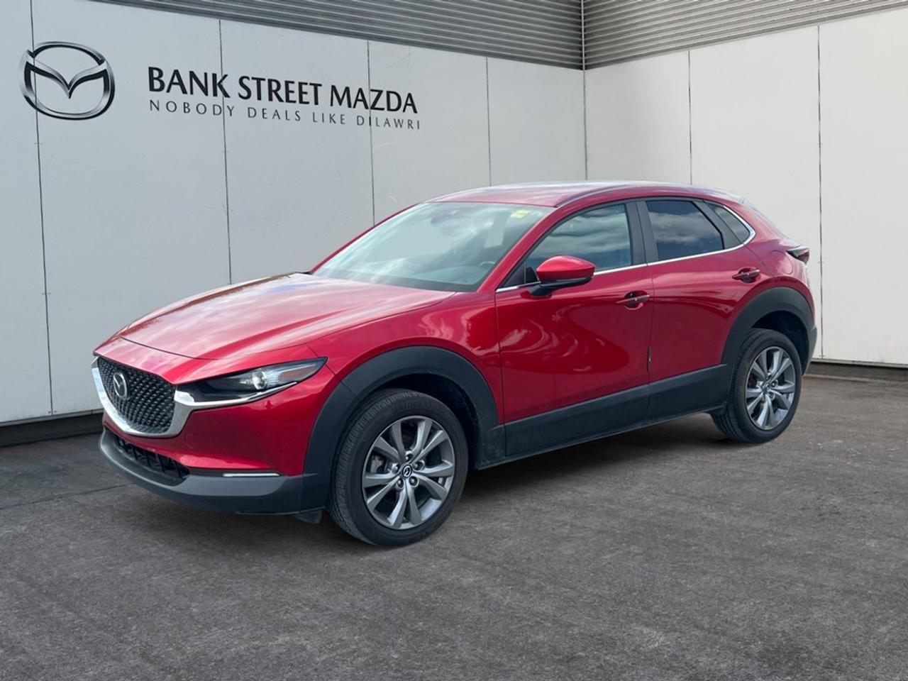 The 2021 Mazda CX-30 GS in striking red with a front-wheel drive configuration offers a dynamic driving experience with its agile handling and responsive performance. The CX-30s sleek design and polished exterior are complemented by stylish alloy wheels, showcasing Mazdas commitment to both aesthetics and functionality. Step inside to experience a thoughtfully crafted interior, featuring luxurious leatherette door trim inserts and a sophisticated leather steering wheel. Comfort is at your fingertips with heated front seats and a heated steering wheel, ensuring an enjoyable drive no matter the season. The smart device integration and Bluetooth connection provide seamless connectivity, allowing you to stay engaged with your daily routine. Advanced technology drives the CX-30s exceptional safety features, including a backup camera and lane assist, which are designed to enhance driver awareness and passenger safety. Adaptive cruise control offers a relaxed driving experience on longer journeys, adjusting to traffic conditions effortlessly. This SUV is ideal for those who seek a combination of style, safety, and advanced technology in their daily driver. Contact us today to learn more about the Mazda CX-30 GS and take it for a test drive. Experience the excellence of Mazda engineering firsthand!