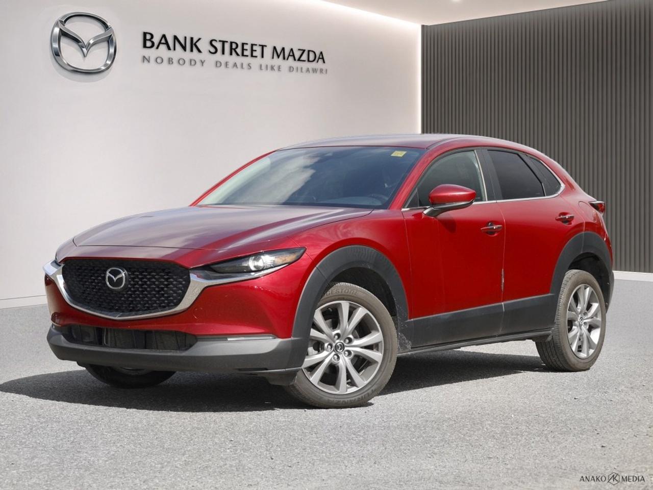 The 2021 Mazda CX-30 GS in striking red with a front-wheel drive configuration offers a dynamic driving experience with its agile handling and responsive performance. The CX-30s sleek design and polished exterior are complemented by stylish alloy wheels, showcasing Mazdas commitment to both aesthetics and functionality. Step inside to experience a thoughtfully crafted interior, featuring luxurious leatherette door trim inserts and a sophisticated leather steering wheel. Comfort is at your fingertips with heated front seats and a heated steering wheel, ensuring an enjoyable drive no matter the season. The smart device integration and Bluetooth connection provide seamless connectivity, allowing you to stay engaged with your daily routine. Advanced technology drives the CX-30s exceptional safety features, including a backup camera and lane assist, which are designed to enhance driver awareness and passenger safety. Adaptive cruise control offers a relaxed driving experience on longer journeys, adjusting to traffic conditions effortlessly. This SUV is ideal for those who seek a combination of style, safety, and advanced technology in their daily driver. Contact us today to learn more about the Mazda CX-30 GS and take it for a test drive. Experience the excellence of Mazda engineering firsthand!