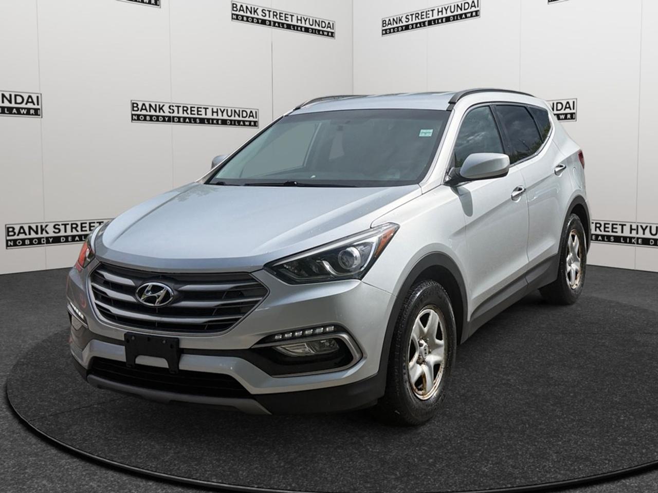 Check out the 2017 Hyundai Santa Fe Sport, available in a refined gray finish with front-wheel drive providing smooth and efficient handling. This SUV is designed to complement your lifestyle with its spacious and inviting interior, featuring heated front seats and mirrors for those chilly Canadian mornings. The stylish exterior is enhanced by sleek alloy wheels and a practical backup camera. Inside, youll enjoy modern convenience with features like air conditioning, keyless entry, and power windows. Stay entertained and connected with Bluetooth technology and satellite radio. This Santa Fe Sport ensures peace of mind with its brake assist system and cruise control for an improved driving experience. Its perfect for families or individuals looking to explore the roads confidently, offering a blend of safety and reliability. Excited to learn more about this fantastic vehicle? Contact Bank Street Hyundai to schedule a test drive or for additional information. Dont miss out on this excellent opportunity to make the 2017 Hyundai Santa Fe Sport yours!