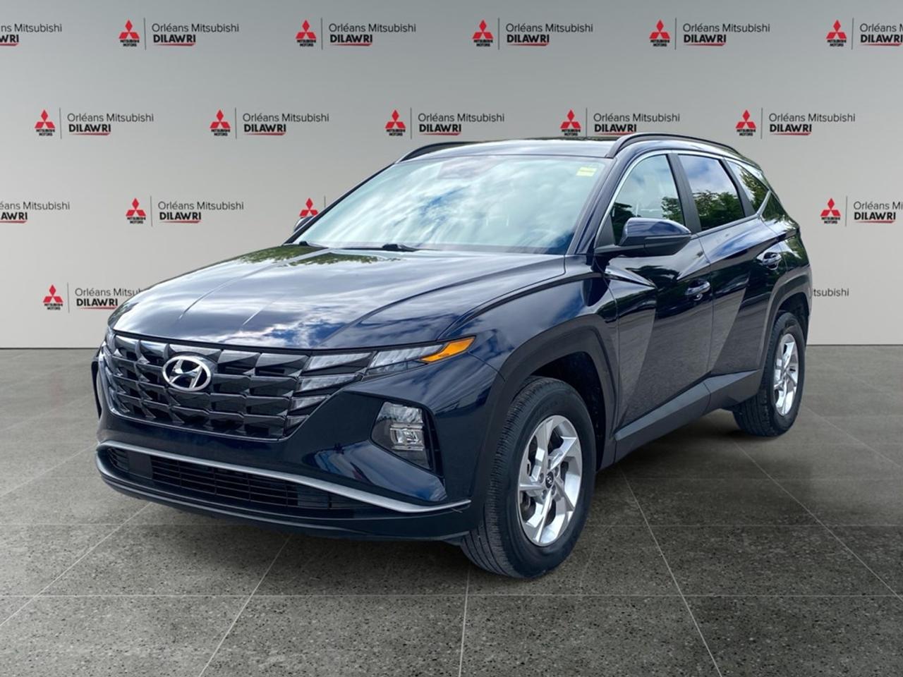 Experience the 2024 Hyundai Tucson Preferred AWD in an eye-catching blue finish. This SUV pairs its robust all-wheel-drive system with effortless handling thanks to its automatic transmission. The exterior boasts elegant alloy wheels and features heated mirrors for those chilly Canadian mornings. Inside, the Tucson offers a refined and comfortable ride with heated front seats and a heated leather steering wheel ensuring warmth and luxury. The leather/metal-look gear shifter adds a touch of sophistication to an already stunning interior. This model comes packed with technology like a backup camera, navigation system, and smart device integration. Stay connected with Bluetooth, and enjoy entertainment on your satellite radio. In terms of safety, the Tucson is equipped with features like brake assist, lane assist, and adaptive cruise control for added peace of mind on every journey. If youre a family seeking a reliable yet stylish SUV or a professional looking for a daily commuter that blends comfort with technology, the Hyundai Tucson Preferred is ideal for you. Contact Orleans Mitsubishi for more information and to schedule a test drive today!