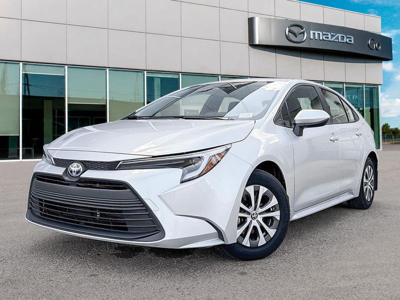 Discover unbeatable efficiency and comfort in this pre-owned 2025 Toyota Corolla Hybrid LE, finished in sleek Grey with a sophisticated Black interior. Powered by a fuel-saving 1.8L 4-cylinder hybrid engine paired with an eCVT transmission, it delivers smooth, responsive performance and exceptional fuel economy.Enjoy heated front bucket seats, an 8 Toyota Multimedia touchscreen, and advanced safety features like lane departure prevention, blind spot warning, and a rear backup camera for peace of mind. With modern conveniences including keyless entry, push-button start, wireless audio streaming, and a spacious cabin with fold-down rear seats, this Corolla Hybrid is perfect for daily commutes and weekend adventures.Experience the perfect blend of eco-friendly driving, comfort, and technology  contact us today to schedule your test drive!Go Mazda is an AMVIC licensed businessThis vehicle was previously used as a Rental