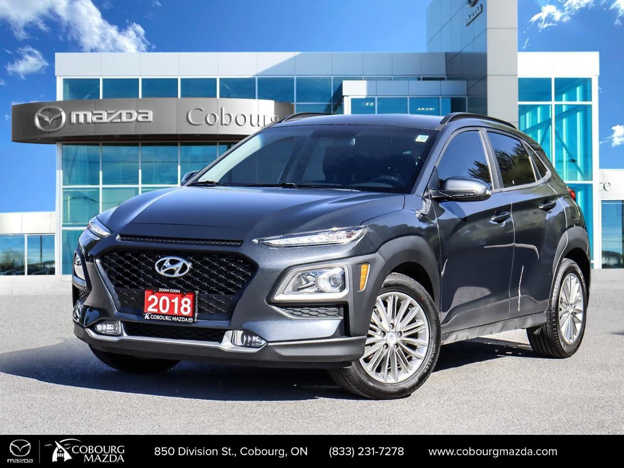 <p>The 2018 Hyundai Kona 2.0L Preferred AWD in a stylish gray hue offers you the dynamic performance of an all-wheel drive SUV. Paired with automatic transmission, its handling is designed to tackle various road conditions effortlessly.</p><p>This Kona captivates with its striking exterior complemented by alloy wheels, and its thoughtful interior features a cozy black finish. Enjoy the comfort of heated seats and appreciate the utility of heated mirrors during those chilly Canadian mornings. The convenience of keyless entry and the refinement of a leather steering wheel make every drive enjoyable.</p><p>Stay connected and drive with peace of mind thanks to its smart device integration, Bluetooth connection, and backup camera. With safety features such as lane assist, brake assist, and parking sensors, the Kona ensures a secure ride for you and your passengers.</p><p>If you're seeking an adventurous and well-equipped SUV, ideal for families or active individuals, this Hyundai Kona is the perfect match. Contact Cobourg Mazda to learn more and arrange a test drive today!</p>