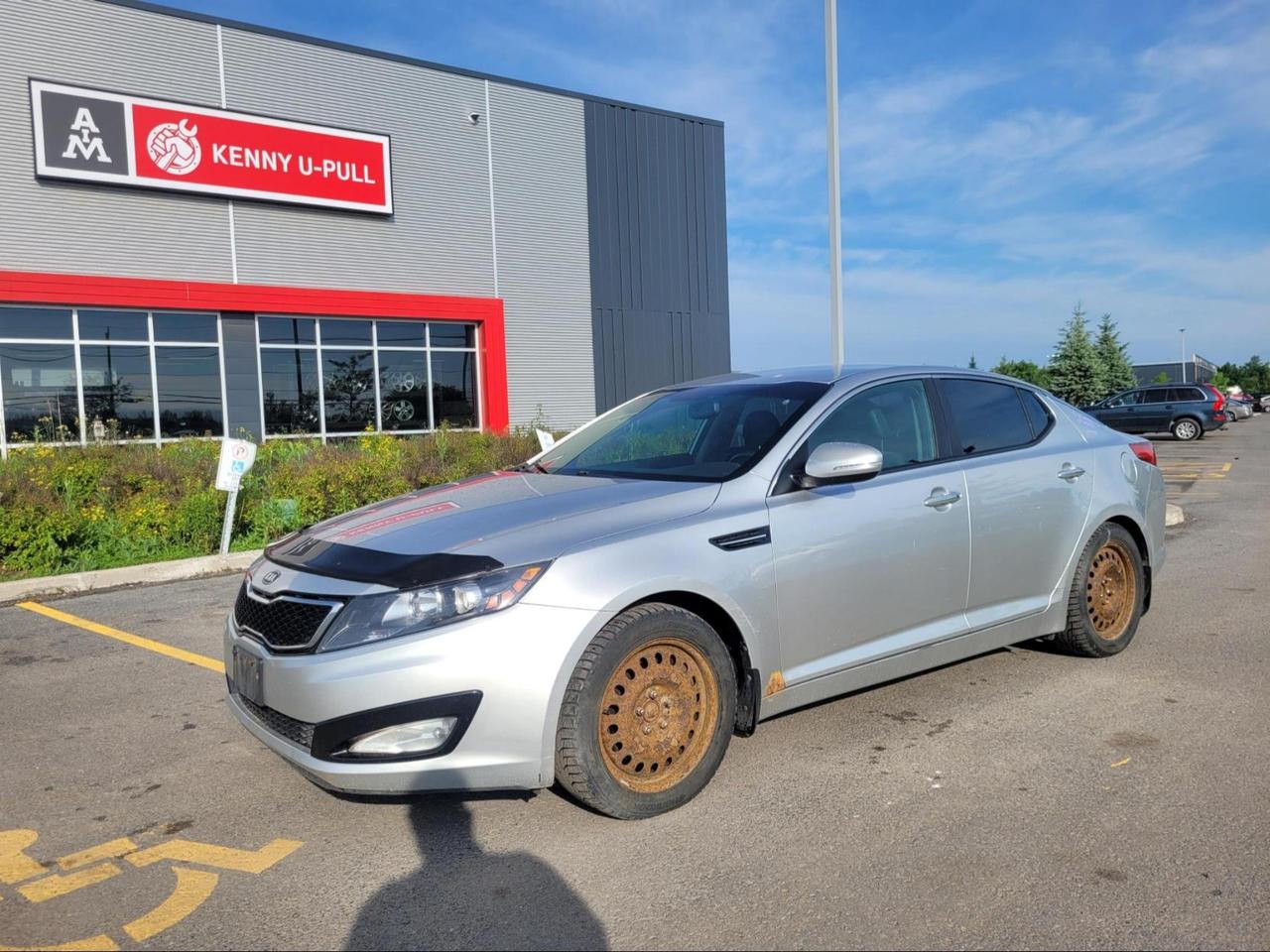 2012 Kia Optima in Bright Silver Metallic. The vehicle has 236,950km. The vehicle runs and drives. No Check engine light. Cracked Windshield. Some imperfections/rust around the body. We dont perform any mechanical/safety inspections. The vehicle is sold as is and might need some work.