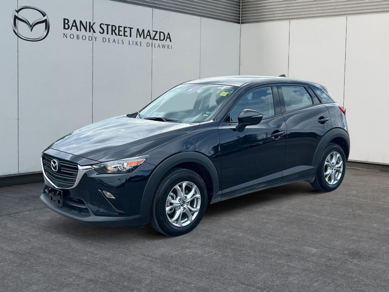 The 2021 Mazda CX-3 GS in stunning white offers a compelling driving experience with its AWD system, ensuring confident handling across various terrains. Its stylish SUV body type stands out with sleek alloy wheels and an aerodynamic design, making it a head-turner wherever you go. Step inside to discover a meticulously crafted interior featuring heated front seats and a heated steering wheel for those chilly Canadian winters. The leather steering wheel and gear shifter add a touch of elegance, while the smart device integration keeps you connected on the road. With comfortable leatherette instrument pane trimming, the ambiance is both modern and inviting. Equipped with the latest technology, the CX-3 offers a range of features such as a Bluetooth connection, keyless entry, and a backup camera for added convenience and safety. Lane assist and brake assist technologies underscore Mazdas commitment to safety. The cruise control feature further enhances driving comfort, allowing for relaxed long-distance journeys. This Mazda CX-3 GS is perfect for the modern driver who values both style and substance. Whether youre navigating city streets or embarking on an out-of-town adventure, this vehicle is designed to meet your needs. For more information, or to take this exceptional SUV for a test drive, contact Bank Street Mazda today!