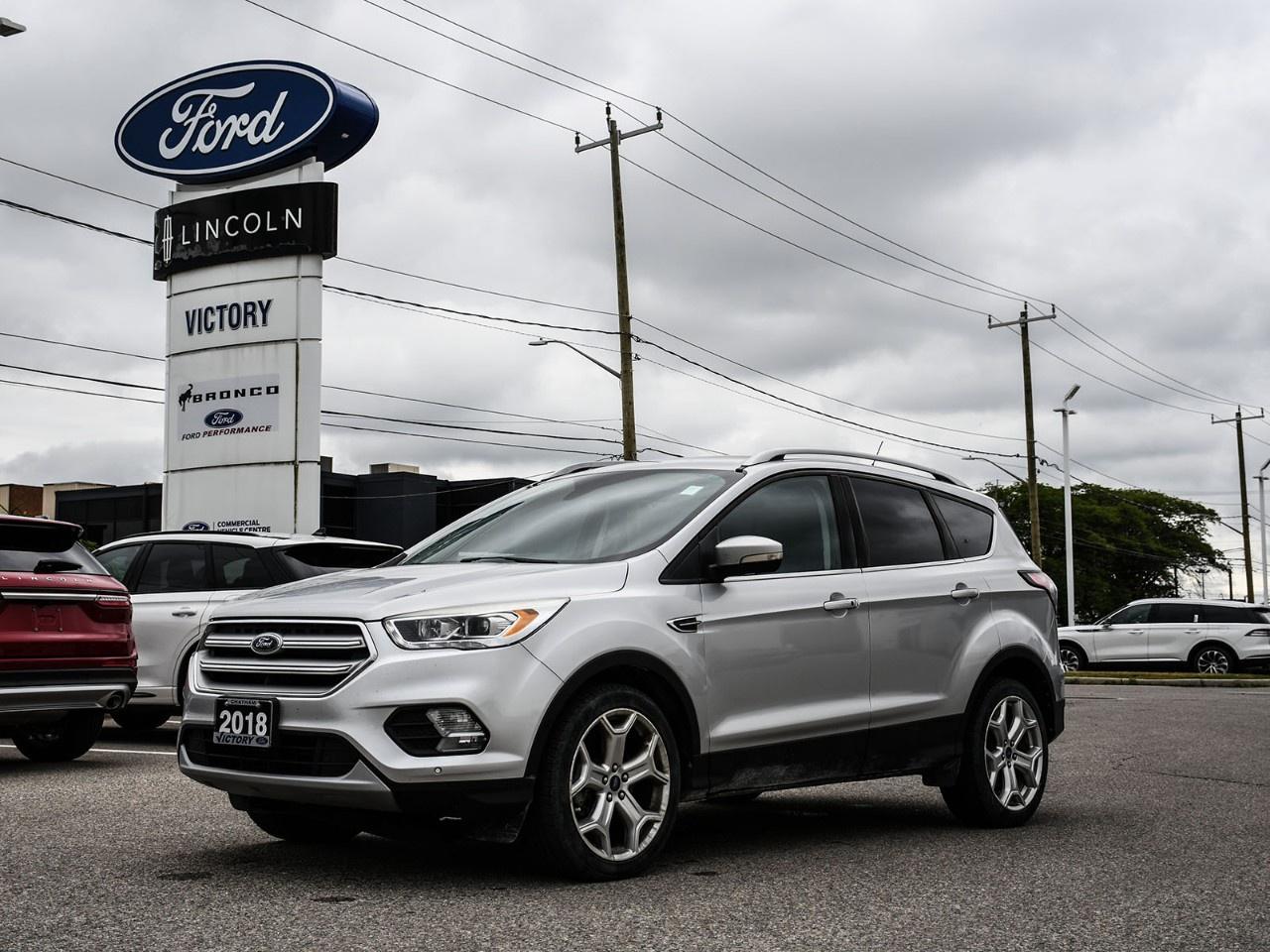 <h2>NOW AVAILABLE AT VICTORY FORD LINCOLN</h2><h1>2018 Ford Escape Titanium AWD 400A</h1><h3>2.0L EcoBoost® Engine  Trailer Tow Package  Upgraded 19" Wheels  Premium Titanium Trim</h3><p>This 2018 Ford Escape Titanium AWD 400A delivers premium comfort, turbocharged performance, and exceptional versatility in a compact SUV. Equipped with the powerful 2.0L EcoBoost® engine, Trailer Tow Package, and upgraded 19" wheels, this Escape offers a refined driving experience with the capability to handle both daily commuting and weekend adventures.</p><h3>POWER & PERFORMANCE</h3><ul><li><p>2.0L EcoBoost® Turbocharged Engine</p></li><li><p>6-Speed SelectShift® Automatic Transmission</p></li><li><p>Intelligent All-Wheel Drive (AWD)</p></li><li><p>245 Horsepower / 275 lb-ft Torque</p></li><li><p>Trailer Tow Package</p></li><li><p>Torque Vectoring Control</p></li></ul><h3>PACKAGE</h3><ul><li><p>400A Titanium Equipment Group</p></li><li><p>2.0L EcoBoost® Engine Upgrade</p></li><li><p>Trailer Tow Package</p></li><li><p>Upgraded 19" Aluminum Wheels</p></li><li><p>Remote Start System</p></li><li><p>Premium Titanium Features</p></li></ul><h3>EXTERIOR FEATURES</h3><ul><li><p>Upgraded 19" Aluminum Wheels</p></li><li><p>Hands-Free Power Liftgate</p></li><li><p>HID Headlamps</p></li><li><p>LED Signature Lighting</p></li><li><p>Chrome Exterior Accents</p></li><li><p>Titanium-Specific Styling</p></li></ul><h3>INTERIOR & COMFORT</h3><ul><li><p>Leather-Trimmed Seating Surfaces</p></li><li><p>10-Way Power Driver Seat</p></li><li><p>Heated Front Seats</p></li><li><p>Heated Steering Wheel</p></li><li><p>Dual-Zone Automatic Climate Control</p></li><li><p>Premium Cabin Materials</p></li></ul><h3>TECHNOLOGY</h3><ul><li><p>SYNC® 3 Infotainment System</p></li><li><p>8" Touchscreen Display</p></li><li><p>Voice-Activated Navigation System</p></li><li><p>Apple CarPlay® & Android Auto</p></li><li><p>Sony® Premium Audio System</p></li><li><p>Rear View Camera</p></li></ul><h3>SAFETY & DRIVER ASSISTANCE</h3><ul><li><p>Blind Spot Information System (BLIS®)</p></li><li><p>Rear Cross Traffic Alert</p></li><li><p>Rear View Camera</p></li><li><p>Reverse Sensing System</p></li><li><p>AdvanceTrac® with Roll Stability Control</p></li><li><p>Traction Control System</p></li><li><p>Tire Pressure Monitoring System</p></li></ul><h3>HIGHLIGHTS</h3><ul><li><p>400A Titanium Equipment Group</p></li><li><p>2.0L EcoBoost® Engine</p></li><li><p>Trailer Tow Package</p></li><li><p>Upgraded 19" Wheels</p></li><li><p>Premium Titanium Interior</p></li><li><p>Strong Towing & AWD Capability</p></li></ul><h3>Special Offer:</h3><p><strong>Peace of Mind Included:</strong> 3-Month Comprehensive Warranty (for vehicles under 10 years old & under 160,000 km) No-Haggle, Live Market Pricing  Transparent & Competitive All-Inclusive Pricing: Fees, Reconditioning, and Full Detailing Included (Taxes & Licensing Extra)</p><h4>Additional Details:</h4><p><strong>Keys:</strong> Standard with one key. Additional keys (if provided by the previous owner) included at no cost. Optional key purchases available upon request.</p><p><strong>Visit Victory Ford Lincoln Today</strong> Schedule your appointment to experience this exceptional vehicle.</p>