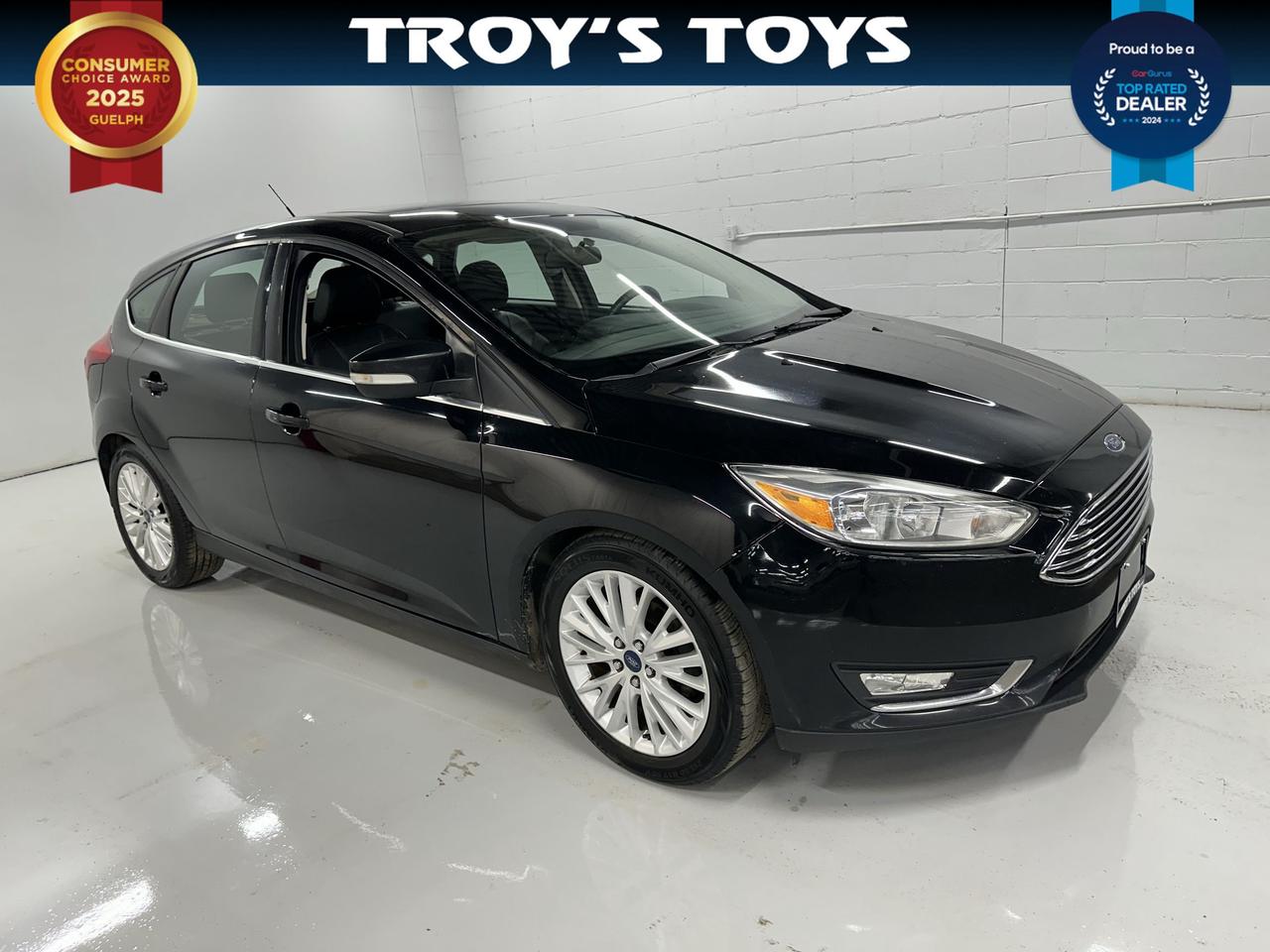 <p>Looking for a stylish and feature-packed ride that wont break the bank? Troys Toys has just what you need with this sleek, pre-owned 2018 Ford Focus Titanium Hatch in a classic black exterior and matching black interior. This isnt just any hatchback; the Titanium trim means youre getting a premium experience, loaded with the technology and comfort youd expect from a higher-end vehicle. With its versatile 4-door hatchback design, its perfect for everything from daily commutes to weekend adventures, offering practicality without sacrificing an ounce of style.</p><p>Under the hood, youll find a capable 2.0L I4 engine paired with a smooth automatic transmission, delivering efficient and responsive performance for all your driving needs. And with front-wheel drive, you can count on reliable handling and stability on Canadian roads. This Focus has seen its fair share of adventures, with 164,196 km on the odometer, proving its been a trusted companion for its previous owner and is ready for many more miles with you.</p><p>This 2018 Ford Focus Titanium Hatch is brimming with features designed to enhance your driving pleasure. At Troys Toys, we know what buyers are looking for, and this vehicle delivers. Get ready to experience a blend of performance, comfort, and advanced technology that makes every drive a joy.</p><p>Here are 5 sizzling features of this 2018 Ford Focus Titanium Hatch:</p><ul><li><strong>Titanium Trim Excellence:</strong> Experience premium comfort and advanced features that elevate your driving experience beyond the ordinary.</li><li><strong>Versatile Hatchback Design:</strong> Enjoy the flexibility of ample cargo space and easy loading, perfect for hauling groceries, gear, or weekend getaways.</li><li><strong>Smooth Automatic Transmission:</strong> Effortlessly navigate city streets and highways with a responsive and seamless automatic gearbox.</li><li><strong>Sleek Black-on-Black Aesthetic:</strong> Turn heads with a sophisticated and timeless look, both inside and out, in a classic black finish.</li><li><strong>Flex Fuel Capability:</strong> Enjoy greater fuel flexibility and potential cost savings, adapting to available fuel options on the go.</li></ul><p><strong><em>Powered by AutoIntelligence&trade;</em></strong></p><p>Vehicle information has been generated using artificial intelligence and is provided for informational purposes only. While efforts are made to ensure accuracy, please confirm all details directly with the dealer.</p>