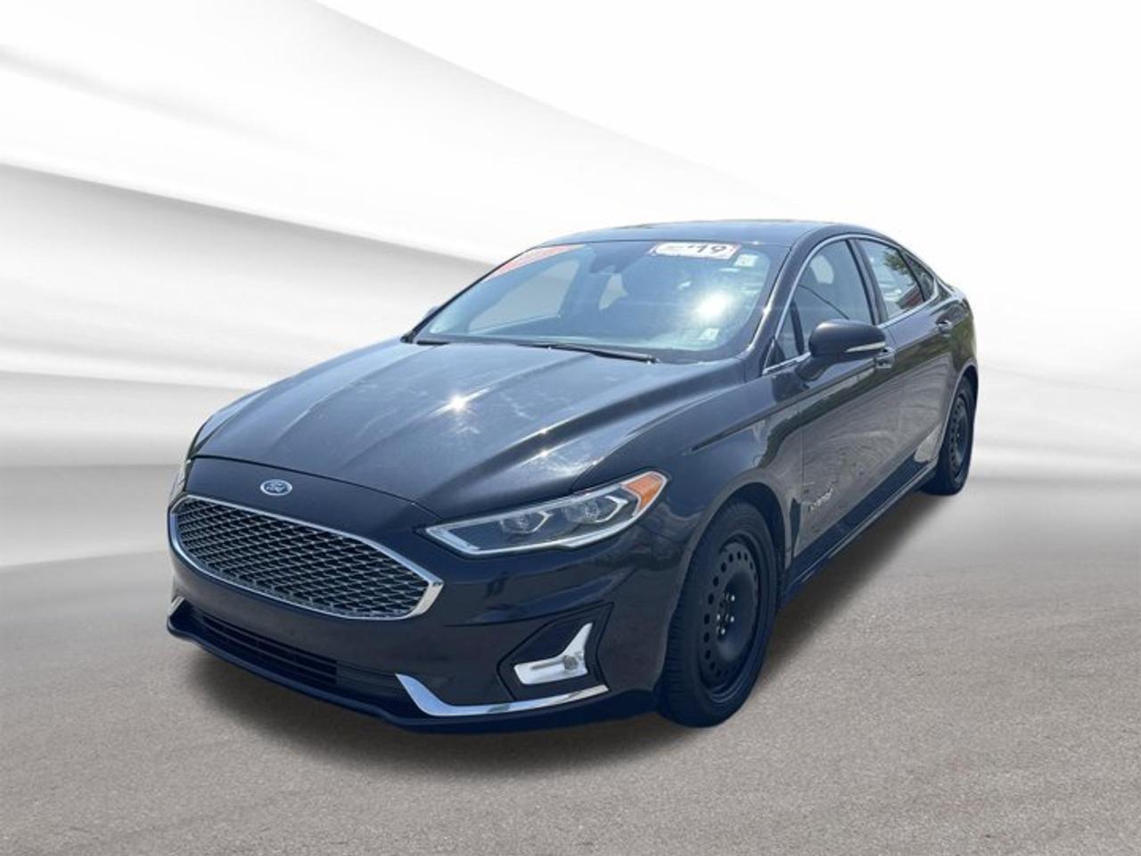 Drive a smart and efficient hybrid sedan with this 2019 Ford Fusion Hybrid Titanium, now available at Steele Halifax Chrysler Dodge Jeep Ram FIAT in Halifax. Finished in Black with a Black interior, this four-door hybrid blends refined comfort, advanced technology, and impressive fuel savings in one well-rounded package.With 138,623 km on the odometer, this used 2019 Ford Fusion Hybrid Titanium continues to offer the smooth, quiet character that makes hybrid driving so appealing. Its Gas/Electric I-4 2.0 L hybrid powertrain works with a CVT automatic transmission and front-wheel drive for easy daily commuting, steady highway manners, and excellent overall efficiency.FEATURES OF THE Fusion Hybrid Titanium2.0-litre hybrid four-cylinder powertrainContinuously variable automatic transmission includedFront-wheel drive for confident handlingFour-door sedan with upscale designHYBRID VEHICLE FEATURESGas-electric system supports lower fuel useRegenerative braking helps recover energyQuiet low-speed hybrid operation in trafficSmooth transitions between gas, electricADVANCED SAFETY FEATURESMultiple airbags for added occupant protectionElectronic stability control for better balanceTraction control supports slippery road startsAnti-lock braking system aids controlPERFORMANCE AND EFFICIENCYHybrid power delivers strong everyday efficiencyCVT supports smooth seamless accelerationFront-wheel drive suits Canadian road conditionsBalanced ride for city commutingCOMFORT AND CONVENIENCEFour-door layout allows easy passenger accessSpacious cabin supports daily driving comfortDual-purpose sedan for work and travelBlack interior offers clean modern styleTECHNOLOGY AND CONNECTIVITYHybrid information display supports efficient drivingDriver-focused controls are easy to reachClear instrument layout improves daily usabilityModern cabin design feels intuitiveCARGO SPACETrunk handles everyday bags and gearSedan design keeps cargo area secureRear space supports errands and tripsWide opening helps loading convenienceAWARDS & RECOGNITIONSTop Safety Pick, Insurance Institute for Highway Safety, 2019WHAT OTHER OWNERS LIKEExcellent fuel economy for daily drivingSmooth quiet ride around townComfortable cabin for longer commutesEasy transition into hybrid ownershipThis hybrid sedan is a smart fit for drivers who want comfort, efficiency, and a polished driving experience without giving up practicality. The 2019 Ford Fusion Hybrid Titanium stands out with its sleek black-on-black look, composed road manners, and the everyday value of a proven hybrid system.If you want a used hybrid sedan that feels refined and efficient for Halifax roads, this 2019 Ford Fusion Hybrid Titanium deserves a close look. Visit Steele Halifax Chrysler Dodge Jeep Ram FIAT in Halifax to see how this hybrid can elevate your daily drive with comfort, confidence, and excellent fuel-saving potential.This 2019 Ford Fusion Hybrid Titaniums VIN is: 3FA6P0RU4KR156112 .We invite you to book a viewing and test drive at your earliest convenience