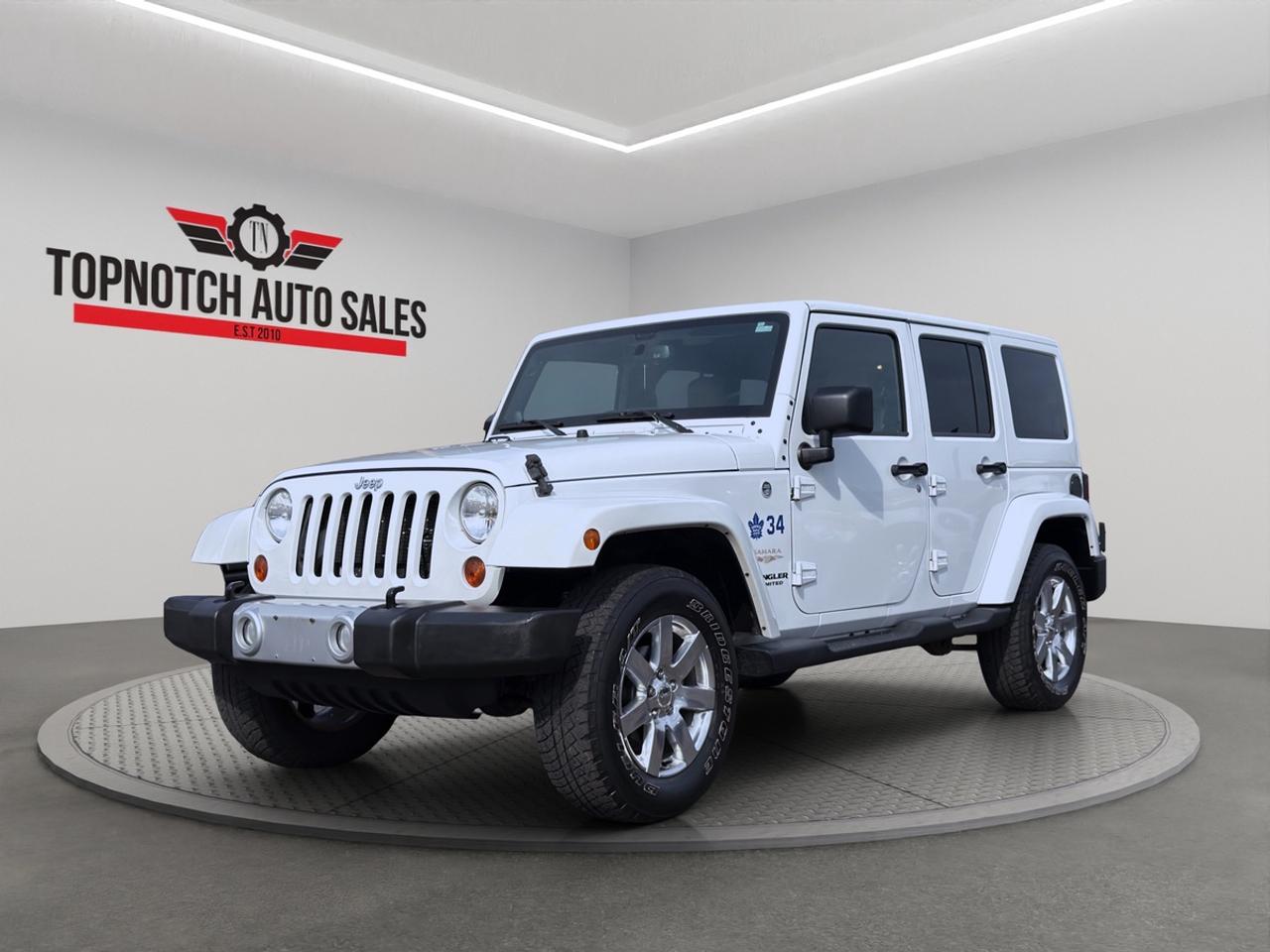 <h1>2013 Jeep Wrangler Sahara</h1><h3>Now Available at Topnotch Auto Sales Inc</h3><p>Experience iconic styling, legendary off-road capability, and open-air freedom with the 2013 Jeep Wrangler Sahara. Designed for adventure while offering everyday comfort, the Wrangler Sahara combines rugged performance with premium features and unmistakable Jeep character. Whether youre exploring off-road trails, heading to the cottage, or cruising through the city, this versatile SUV is built to handle it all.</p><h2>Performance & Capability</h2><p>The 2013 Jeep Wrangler Sahara is powered by a robust 3.6L Pentastar V6 engine paired with a smooth automatic transmission, delivering strong performance both on and off the road. Its advanced 4x4 system, durable suspension, and impressive ground clearance provide the confidence needed to tackle challenging terrain while maintaining a comfortable ride on paved roads.</p><p>Key performance highlights include:</p><ul><li>3.6L Pentastar V6 engine</li><li>Automatic transmission</li><li>Legendary Jeep 4x4 capability</li><li>Heavy-duty suspension system</li><li>Exceptional ground clearance</li><li>Trail-rated off-road performance</li><li>Strong towing capability</li><li>Confident handling in various weather and road conditions</li></ul><p>Built for adventure, the Wrangler Sahara delivers capability without compromise.</p><h2>Interior Comfort & Features</h2><p>Step inside and enjoy a cabin that blends rugged durability with premium comfort, featuring:</p><ul><li>Premium cloth seating with Sahara trim accents</li><li>Heated front seats</li><li>Leather-wrapped steering wheel</li><li>Air conditioning with climate control</li><li>Power windows, locks, and mirrors</li><li>Remote keyless entry</li><li>Spacious seating for passengers</li><li>Folding rear seats for increased cargo versatility</li><li>Removable Freedom Top panels for open-air driving</li><li>Durable interior materials designed for active lifestyles</li></ul><p>The Sahara trim adds extra refinement while maintaining the Wranglers adventurous spirit.</p><h2>Technology & Connectivity</h2><p>Stay connected and entertained wherever the journey takes you with convenient technology features, including:</p><ul><li>Touchscreen infotainment system</li><li>Bluetooth hands-free calling</li><li>Premium audio system</li><li>USB and auxiliary audio inputs</li><li>Steering wheel-mounted audio controls</li><li>Satellite radio capability</li><li>Vehicle information display</li><li>Cruise control</li></ul><p>The Wrangler Sahara offers the perfect balance of rugged utility and modern convenience.</p><h2>Safety & Peace of Mind</h2><p>The 2013 Jeep Wrangler Sahara includes a range of safety features designed to help protect you and your passengers, including:</p><ul><li>Electronic Stability Control (ESC)</li><li>Anti-lock Braking System (ABS)</li><li>Traction Control System</li><li>Advanced multistage front airbags</li><li>Tire Pressure Monitoring System (TPMS)</li><li>Hill Start Assist</li><li>Trailer Sway Control</li><li>Roll Mitigation Technology</li><li>Durable body-on-frame construction</li></ul><p>Drive confidently knowing your Wrangler is engineered with safety and durability in mind.</p><h2>Vehicle Condition</h2><p>This 2013 Jeep Wrangler Sahara is in excellent, non-smoking condition both inside and out. Professionally detailed and thoroughly inspected, it reflects careful ownership and proper maintenance. Ready for its next adventure and its next proud owner.</p><h2>Why Shop with Topnotch Auto Sales Inc?</h2><p>At Topnotch Auto Sales Inc, we are committed to providing quality pre-owned vehicles backed by exceptional customer service. Our experienced team works hard to ensure every purchase is transparent, straightforward, and stress-free.</p><h2>Flexible Financing Solutions</h2><p>We offer quick and easy financing approvals for all credit situations, including:</p><ul><li>Bad Credit</li><li>No Credit</li><li>New Credit</li><li>Previous Financial Challenges</li></ul><p>Enjoy same-day approvals, competitive interest rates, and flexible low down payment options tailored to your needs.</p><h2>Certification Option</h2><p>Choose to certify this 2013 Jeep Wrangler Sahara for only <strong>$799</strong>. Certification ensures the vehicle meets all current Ontario safety standards for added confidence and peace of mind.</p><h2>OMVIC Compliance</h2><p><strong>Important:</strong> Uncertified vehicles are offered asis and must be certified to comply with OMVIC regulations for road use. Our team is happy to assist you through the certification process and answer any questions you may have.</p><p>With over 14 years of automotive industry experience, Topnotch Auto Sales Inc has earned a reputation for integrity, quality inventory, and customer-focused service. We are proud to be your trusted destination for hassle-free vehicle shopping.</p><h3> Come Visit Us</h3><p>5455 Steeles Ave W, North York, ON M9L 1S7</p><h3> Call or Text</h3><p>416-879-7113</p>