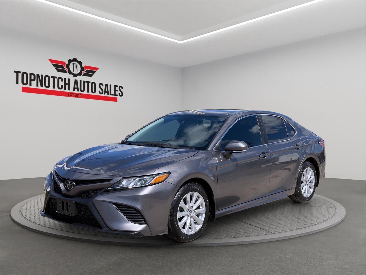 <p style=margin: 0.0px 0.0px 0.0px 0.0px; font: 13.0px Helvetica Neue><strong>2019 Toyota Camry SE Auto</strong></p><p style=margin: 0.0px 0.0px 0.0px 0.0px; font: 13.0px Helvetica Neue><strong>Now Available at Topnotch Auto Sales Inc</strong></p><p style=margin: 0.0px 0.0px 0.0px 0.0px; font: 13.0px Helvetica Neue>Experience the perfect combination of reliability, comfort, fuel efficiency, and sporty styling with this <strong>2019 Toyota Camry SE</strong>. Known for its dependable performance, spacious interior, and excellent fuel economy, the Camry is an ideal choice for commuting, family driving, and long road trips.</p><p style=margin: 0.0px 0.0px 2.0px 0.0px; font: 16.0px Helvetica Neue><strong>Performance & Efficiency</strong></p><p style=margin: 0.0px 0.0px 0.0px 0.0px; font: 13.0px Helvetica Neue>Powered by a responsive <strong>2.5L 4-cylinder engine</strong> paired with a smooth automatic transmission, the Toyota Camry delivers a comfortable and confident driving experience.</p><p style=margin: 0.0px 0.0px 0.0px 0.0px; font: 13.0px Helvetica Neue><strong>Performance Highlights:</strong></p><ul style=list-style-type: disc><li style=margin: 0.0px 0.0px 0.0px 0.0px; font: 13.0px Helvetica Neue>2.5L 4-Cylinder Engine</li><li style=margin: 0.0px 0.0px 0.0px 0.0px; font: 13.0px Helvetica Neue>Automatic Transmission</li><li style=margin: 0.0px 0.0px 0.0px 0.0px; font: 13.0px Helvetica Neue>Front-Wheel Drive (FWD)</li><li style=margin: 0.0px 0.0px 0.0px 0.0px; font: 13.0px Helvetica Neue>Smooth and responsive handling</li><li style=margin: 0.0px 0.0px 0.0px 0.0px; font: 13.0px Helvetica Neue>Excellent fuel efficiency</li><li style=margin: 0.0px 0.0px 0.0px 0.0px; font: 13.0px Helvetica Neue>Comfortable everyday driving</li><li style=margin: 0.0px 0.0px 0.0px 0.0px; font: 13.0px Helvetica Neue>Sporty SE styling</li></ul><p style=margin: 0.0px 0.0px 0.0px 0.0px; font: 13.0px Helvetica Neue><strong>Fuel Economy:</strong></p><ul style=list-style-type: disc><li style=margin: 0.0px 0.0px 0.0px 0.0px; font: 13.0px Helvetica Neue>City: <strong>8.4 L/100 km</strong></li><li style=margin: 0.0px 0.0px 0.0px 0.0px; font: 13.0px Helvetica Neue>Highway: <strong>6.1 L/100 km</strong></li></ul><p style=margin: 0.0px 0.0px 0.0px 0.0px; font: 13.0px Helvetica Neue>The Camry offers an excellent balance of performance and fuel efficiency, making it a great choice for both city commuting and highway driving.</p><p style=margin: 0.0px 0.0px 2.0px 0.0px; font: 16.0px Helvetica Neue><strong>Interior Comfort & Convenience</strong></p><p style=margin: 0.0px 0.0px 0.0px 0.0px; font: 13.0px Helvetica Neue>Enjoy a spacious and thoughtfully designed cabin built around comfort and everyday practicality.</p><p style=margin: 0.0px 0.0px 0.0px 0.0px; font: 13.0px Helvetica Neue><strong>Interior Features Include:</strong></p><ul style=list-style-type: disc><li style=margin: 0.0px 0.0px 0.0px 0.0px; font: 13.0px Helvetica Neue>Comfortable seating for up to five passengers</li><li style=margin: 0.0px 0.0px 0.0px 0.0px; font: 13.0px Helvetica Neue>Black interior</li><li style=margin: 0.0px 0.0px 0.0px 0.0px; font: 13.0px Helvetica Neue>Supportive front seats</li><li style=margin: 0.0px 0.0px 0.0px 0.0px; font: 13.0px Helvetica Neue>Air conditioning</li><li style=margin: 0.0px 0.0px 0.0px 0.0px; font: 13.0px Helvetica Neue>Power windows</li><li style=margin: 0.0px 0.0px 0.0px 0.0px; font: 13.0px Helvetica Neue>Power door locks</li><li style=margin: 0.0px 0.0px 0.0px 0.0px; font: 13.0px Helvetica Neue>Tilt and telescopic steering wheel</li><li style=margin: 0.0px 0.0px 0.0px 0.0px; font: 13.0px Helvetica Neue>Cruise control</li><li style=margin: 0.0px 0.0px 0.0px 0.0px; font: 13.0px Helvetica Neue>Spacious trunk</li><li style=margin: 0.0px 0.0px 0.0px 0.0px; font: 13.0px Helvetica Neue>Ample cabin storage</li></ul><p style=margin: 0.0px 0.0px 0.0px 0.0px; font: 13.0px Helvetica Neue>Whether youre commuting to work or heading out on a road trip, the Camry provides a comfortable and refined driving environment.</p><p style=margin: 0.0px 0.0px 2.0px 0.0px; font: 16.0px Helvetica Neue><strong>Technology & Connectivity</strong></p><p style=margin: 0.0px 0.0px 0.0px 0.0px; font: 13.0px Helvetica Neue>Stay connected and entertained while on the road.</p><p style=margin: 0.0px 0.0px 0.0px 0.0px; font: 13.0px Helvetica Neue><strong>Technology Features Include:</strong></p><ul style=list-style-type: disc><li style=margin: 0.0px 0.0px 0.0px 0.0px; font: 13.0px Helvetica Neue>Bluetooth® hands-free calling and audio streaming</li><li style=margin: 0.0px 0.0px 0.0px 0.0px; font: 13.0px Helvetica Neue>AM/FM audio system</li><li style=margin: 0.0px 0.0px 0.0px 0.0px; font: 13.0px Helvetica Neue>USB connectivity</li><li style=margin: 0.0px 0.0px 0.0px 0.0px; font: 13.0px Helvetica Neue>Steering-wheel-mounted audio controls</li><li style=margin: 0.0px 0.0px 0.0px 0.0px; font: 13.0px Helvetica Neue>Multi-function driver information display</li><li style=margin: 0.0px 0.0px 0.0px 0.0px; font: 13.0px Helvetica Neue>Touchscreen infotainment system</li><li style=margin: 0.0px 0.0px 0.0px 0.0px; font: 13.0px Helvetica Neue>Apple CarPlay® compatibility</li><li style=margin: 0.0px 0.0px 0.0px 0.0px; font: 13.0px Helvetica Neue>12V power outlet</li><li style=margin: 0.0px 0.0px 0.0px 0.0px; font: 13.0px Helvetica Neue>Cruise control</li></ul><p style=margin: 0.0px 0.0px 2.0px 0.0px; font: 16.0px Helvetica Neue><strong>Safety & Driver Assistance</strong></p><p style=margin: 0.0px 0.0px 0.0px 0.0px; font: 13.0px Helvetica Neue>The <strong>2019 Toyota Camry SE</strong> comes equipped with advanced safety features designed to provide added confidence on every drive.</p><p style=margin: 0.0px 0.0px 0.0px 0.0px; font: 13.0px Helvetica Neue><strong>Safety Features Include:</strong></p><ul style=list-style-type: disc><li style=margin: 0.0px 0.0px 0.0px 0.0px; font: 13.0px Helvetica Neue>Anti-lock Braking System (ABS)</li><li style=margin: 0.0px 0.0px 0.0px 0.0px; font: 13.0px Helvetica Neue>Electronic Stability Control</li><li style=margin: 0.0px 0.0px 0.0px 0.0px; font: 13.0px Helvetica Neue>Traction Control</li><li style=margin: 0.0px 0.0px 0.0px 0.0px; font: 13.0px Helvetica Neue>Brake Assist</li><li style=margin: 0.0px 0.0px 0.0px 0.0px; font: 13.0px Helvetica Neue>Tire Pressure Monitoring System (TPMS)</li><li style=margin: 0.0px 0.0px 0.0px 0.0px; font: 13.0px Helvetica Neue>Multiple airbags</li><li style=margin: 0.0px 0.0px 0.0px 0.0px; font: 13.0px Helvetica Neue>Rearview camera</li><li style=margin: 0.0px 0.0px 0.0px 0.0px; font: 13.0px Helvetica Neue>Lane Departure Alert</li><li style=margin: 0.0px 0.0px 0.0px 0.0px; font: 13.0px Helvetica Neue>Lane Keeping Assist</li><li style=margin: 0.0px 0.0px 0.0px 0.0px; font: 13.0px Helvetica Neue>Pre-Collision System</li><li style=margin: 0.0px 0.0px 0.0px 0.0px; font: 13.0px Helvetica Neue>Automatic High Beams</li><li style=margin: 0.0px 0.0px 0.0px 0.0px; font: 13.0px Helvetica Neue>LATCH child seat anchors</li></ul><p style=margin: 0.0px 0.0px 2.0px 0.0px; font: 16.0px Helvetica Neue><strong>Vehicle Information</strong></p><ul style=list-style-type: disc><li style=margin: 0.0px 0.0px 0.0px 0.0px; font: 13.0px Helvetica Neue><strong>Price:</strong> $16,950</li><li style=margin: 0.0px 0.0px 0.0px 0.0px; font: 13.0px Helvetica Neue><strong>Odometer:</strong> 140,069 KM</li><li style=margin: 0.0px 0.0px 0.0px 0.0px; font: 13.0px Helvetica Neue><strong>Stock Number:</strong> 817940</li><li style=margin: 0.0px 0.0px 0.0px 0.0px; font: 13.0px Helvetica Neue><strong>VIN:</strong> 4T1B11HKXKU817940</li><li style=margin: 0.0px 0.0px 0.0px 0.0px; font: 13.0px Helvetica Neue><strong>Exterior Color:</strong> Gray</li><li style=margin: 0.0px 0.0px 0.0px 0.0px; font: 13.0px Helvetica Neue><strong>Interior Color:</strong> Black</li><li style=margin: 0.0px 0.0px 0.0px 0.0px; font: 13.0px Helvetica Neue><strong>Body Style:</strong> Sedan</li><li style=margin: 0.0px 0.0px 0.0px 0.0px; font: 13.0px Helvetica Neue><strong>Doors:</strong> 4</li><li style=margin: 0.0px 0.0px 0.0px 0.0px; font: 13.0px Helvetica Neue><strong>Passengers:</strong> 5</li><li style=margin: 0.0px 0.0px 0.0px 0.0px; font: 13.0px Helvetica Neue><strong>Engine:</strong> 2.5L 4-Cylinder</li><li style=margin: 0.0px 0.0px 0.0px 0.0px; font: 13.0px Helvetica Neue><strong>Transmission:</strong> Automatic</li><li style=margin: 0.0px 0.0px 0.0px 0.0px; font: 13.0px Helvetica Neue><strong>Drivetrain:</strong> FWD</li><li style=margin: 0.0px 0.0px 0.0px 0.0px; font: 13.0px Helvetica Neue><strong>Fuel Type:</strong> Gasoline</li></ul><p style=margin: 0.0px 0.0px 2.0px 0.0px; font: 16.0px Helvetica Neue><strong>Topnotch Auto Sales  Your Trusted Source for Quality Pre-Owned Vehicles</strong></p><p style=margin: 0.0px 0.0px 0.0px 0.0px; font: 13.0px Helvetica Neue>At Topnotch Auto Sales Inc, we are committed to offering quality vehicles, exceptional customer service, and flexible financing solutions tailored to your needs.</p><p style=margin: 0.0px 0.0px 2.0px 0.0px; font: 16.0px Helvetica Neue><strong>Financing Available</strong></p><p style=margin: 0.0px 0.0px 0.0px 0.0px; font: 13.0px Helvetica Neue>We work with all credit situations:</p><ul style=list-style-type: disc><li style=margin: 0.0px 0.0px 0.0px 0.0px; font: 13.0px Helvetica Neue>Good Credit</li><li style=margin: 0.0px 0.0px 0.0px 0.0px; font: 13.0px Helvetica Neue>Bad Credit</li><li style=margin: 0.0px 0.0px 0.0px 0.0px; font: 13.0px Helvetica Neue>No Credit</li><li style=margin: 0.0px 0.0px 0.0px 0.0px; font: 13.0px Helvetica Neue>New to Canada</li><li style=margin: 0.0px 0.0px 0.0px 0.0px; font: 13.0px Helvetica Neue>Self-Employed</li></ul><p style=margin: 0.0px 0.0px 0.0px 0.0px; font: 13.0px Helvetica Neue>Fast approvals and low down payment options available.</p><p style=margin: 0.0px 0.0px 2.0px 0.0px; font: 16.0px Helvetica Neue><strong>Certification Available</strong></p><p style=margin: 0.0px 0.0px 0.0px 0.0px; font: 13.0px Helvetica Neue>Vehicle can be certified for only <strong>$799</strong>.</p><p style=margin: 0.0px 0.0px 0.0px 0.0px; font: 13.0px Helvetica Neue>Certification includes a comprehensive inspection to meet Ontario safety standards.</p><p style=margin: 0.0px 0.0px 2.0px 0.0px; font: 16.0px Helvetica Neue><strong>OMVIC Disclosure</strong></p><p style=margin: 0.0px 0.0px 0.0px 0.0px; font: 13.0px Helvetica Neue>As per OMVIC regulations, this vehicle is currently being sold as<span id=jodit-selection_marker_1787693746920_06834866083927715 data-jodit-selection_marker=start style=line-height: 0; display: none;></span>is and is not certified unless otherwise stated. Certification is available at an additional cost.</p><p style=margin: 0.0px 0.0px 0.0px 0.0px; font: 13.0px Helvetica Neue>With over 14 years of experience, Topnotch Auto Sales Inc is dedicated to providing a smooth, transparent, and stress-free car-buying experience.</p><p style=margin: 0.0px 0.0px 0.0px 0.0px; font: 13.0px Helvetica Neue><strong>Price: $16,950</strong></p><p style=margin: 0.0px 0.0px 0.0px 0.0px; font: 13.0px Helvetica Neue> <strong>Visit Us:</strong><br>5455 Steeles Ave W, North York, ON M9L 1S7</p><p style=margin: 0.0px 0.0px 0.0px 0.0px; font: 13.0px Helvetica Neue><span style=font: 13.0px .Apple Color Emoji UI></span> <strong>Call or Text:</strong><br>416-879-7113</p>