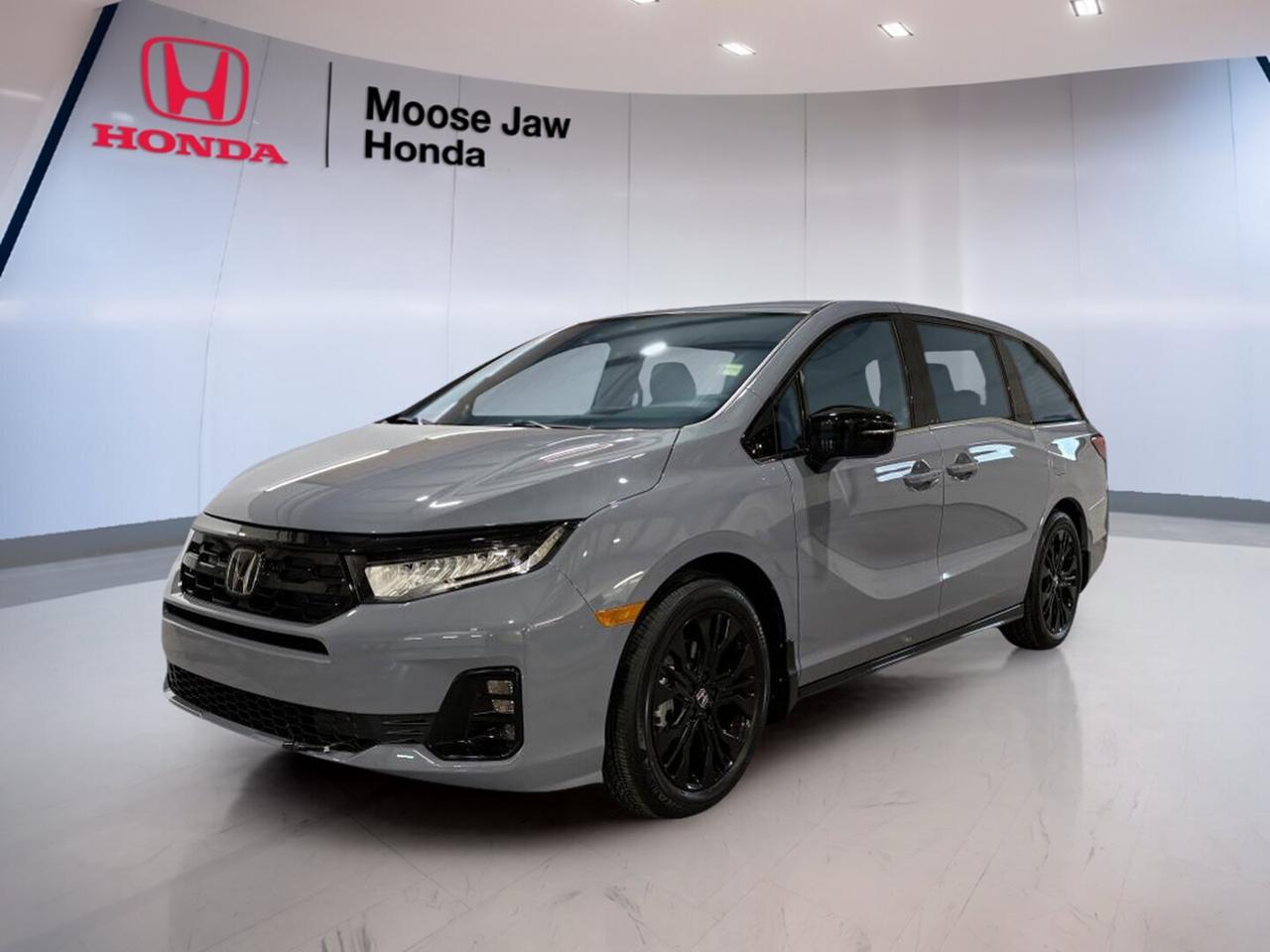 Meet the brand new 2026 Honda Odyssey Black Edition at Moose Jaw Honda in Moose Jaw. Finished in Grey with a Black interior, this family-focused minivan pairs bold style with proven Honda capability. The 2026 Honda Odyssey Black Edition is built to make daily driving, road trips, and busy family schedules feel easier.

Power comes from a 3.5-litre 24-valve direct-injection SOHC i-VTEC V6 engine matched to a 10-speed automatic transmission with shift capability. Front-wheel drive helps deliver confident traction and smooth road manners. The 2026 Honda Odyssey Black Edition is known for strong passing power, refined cruising, and a composed ride.

FEATURES OF THE Odyssey Black Edition
»» Blacked-out exterior trim adds bold presence
»» Exclusive Black Edition styling details throughout
»» Grey exterior pairs with Black interior
»» V6 power supports smooth family travel

ADVANCED SAFETY FEATURES
»» Advanced airbag system helps protect occupants
»» Stability assist supports controlled cornering behaviour
»» Traction control helps manage slippery roads
»» Anti-lock brakes support confident stopping performance

PERFORMANCE AND EFFICIENCY
»» 3.5-litre V6 delivers smooth strong acceleration
»» 10-speed automatic supports refined highway cruising
»» Front-wheel drive offers balanced everyday handling
»» i-VTEC design helps optimize engine response

COMFORT AND CONVENIENCE
»» Spacious cabin supports growing family needs
»» Easy entry layout helps daily loading
»» Smooth automatic shifting reduces driver effort
»» Quiet ride improves comfort on trips

TECHNOLOGY AND CONNECTIVITY
»» Clear driver information supports easy monitoring
»» Shift mode adds convenient driving control
»» Modern controls are simple to use
»» Thoughtful cabin layout improves accessibility

CARGO SPACE
»» Large rear cargo area fits essentials
»» Minivan design supports flexible loading needs
»» Wide opening helps load bulky items
»» Cabin storage helps organize daily gear

WHAT OTHER OWNERS LIKE
»» Strong V6 power for highway merging
»» Smooth ride for family road trips
»» Flexible interior for passengers and cargo
»» Easy driving manners in city traffic

The 2026 Honda Odyssey Black Edition is a smart pick for drivers who want space, power, and everyday practicality in one polished package. Its minivan layout is ideal for family life, while the V6 engine and 10-speed automatic transmission help it feel refined and capable on every drive.

This brand new 2026 Honda Odyssey Black Edition also stands out with its confident appearance. The Grey exterior gives it a clean, upscale look, while the Black interior adds a sleek and modern feel. Together, they create a premium atmosphere that suits both weekday errands and weekend travel.

At Moose Jaw Honda, this 2026 Honda Odyssey Black Edition offers the value of a new vehicle with the comfort and versatility families want most. If you need room for passengers, useful cargo flexibility, and trusted Honda engineering, this minivan is ready to deliver.

This 2026 Honda Odyssey Black Editions VIN is: 5FNRL6H01TB503239 .
