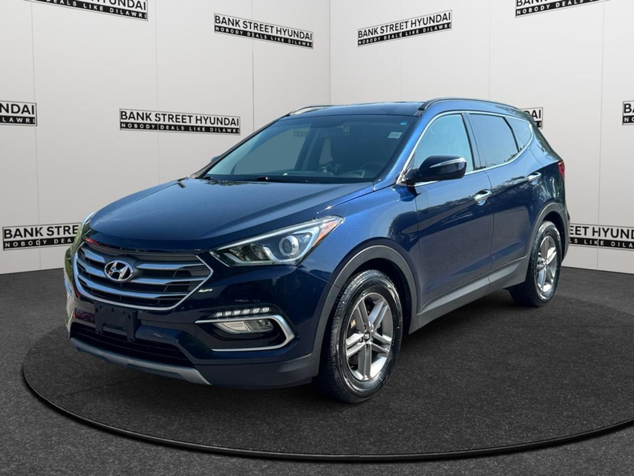 Experience the perfect blend of style and performance with the 2017 Hyundai Santa Fe Sport, finished in a stunning blue exterior. This SUV is equipped with an advanced AWD drivetrain and smooth automatic transmission, promising superior handling in various driving conditions. The Santa Fe Sport Premium impresses with its aesthetic appeal and functionality. Its sleek body is complemented by alloy wheels, while the interior offers comforting features like heated front and rear seats, a leather steering wheel, and a leather/piano black gear shifter. Enjoy the practicality of power seats and windows and the ease of keyless entry. Technology and safety are at the forefront, featuring a user-friendly backup camera, parking sensors, and lane assist for a secure driving experience. Stay connected and entertained with Bluetooth connectivity and satellite radio, and keep your cabin comfortable with air conditioning. Brake assist and cruise control further enhance your driving convenience. Ideal for families and individuals seeking a reliable and stylish SUV, this Hyundai Santa Fe Sport also caters to those with a taste for comfort and technology. Contact Bank Street Hyundai today to learn more and schedule a test drive!