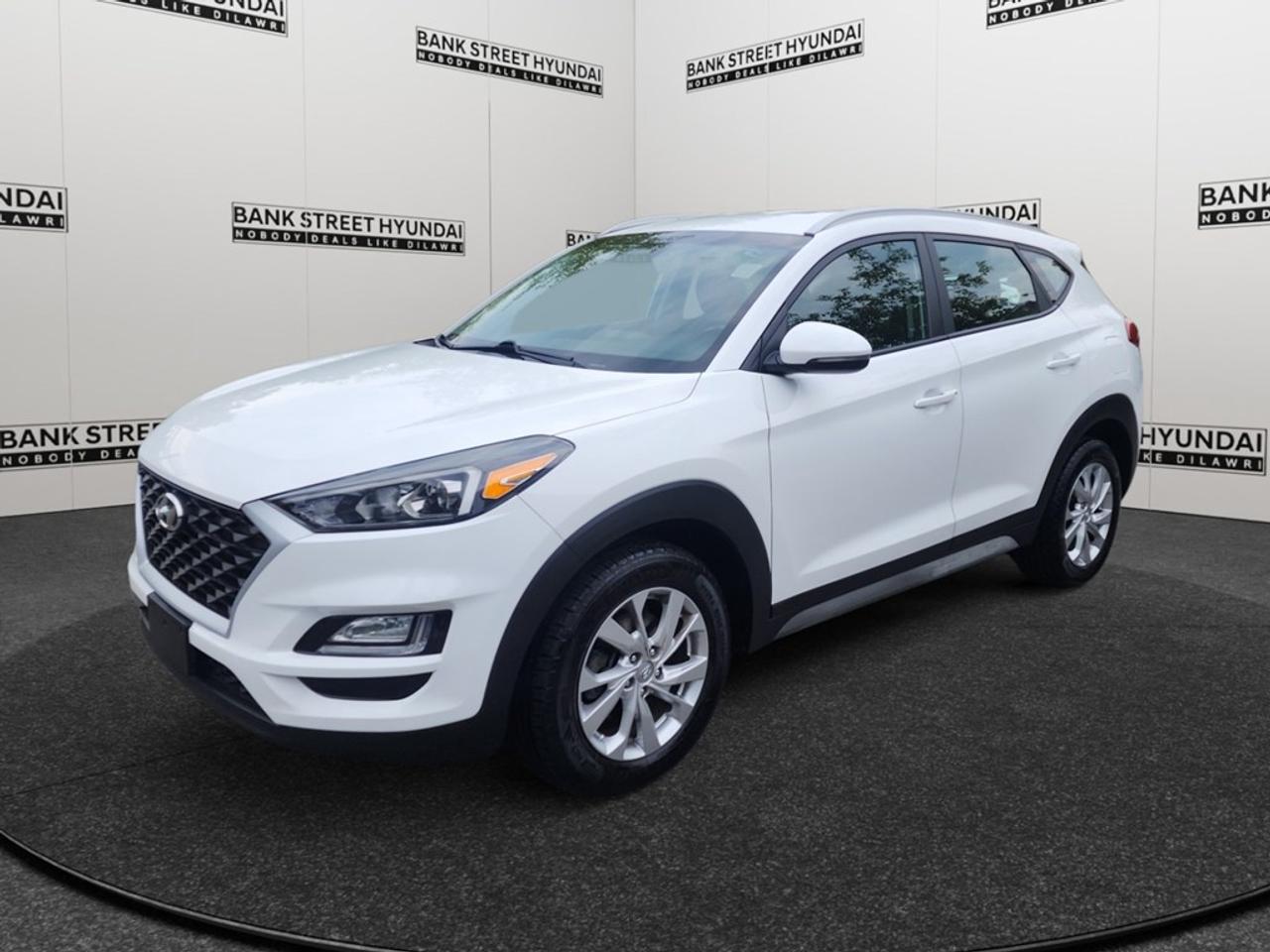 The 2019 Hyundai Tucson Preferred in a stunning white finish offers a smooth and efficient driving experience with its forward-wheel drive and automatic transmission. Designed to handle urban roads with ease, this compact SUV delivers both style and practicality. The exterior of the Tucson boasts elegant lines complemented by alloy wheels that add a touch of sophistication. Step inside to find a well-crafted interior featuring comfortable heated front and rear seats wrapped in quality materials, perfect for those chilly Canadian mornings. Enjoy the convenience of a leather-wrapped steering wheel and gear shifter, adding a dash of luxury to your driving experience. Equipped with the latest technology, this Tucson includes smart device integration and Bluetooth connectivity to make every journey enjoyable. Stay safe and secure with advanced features like lane assist, a backup camera, and brake assist. With heated mirrors and a heated steering wheel, driving in winter conditions is more comfortable than ever. This vehicle is perfect for families or individuals seeking a reliable and stylish SUV that doesnt compromise on features or comfort. Contact Bank Street Hyundai today to learn more about how you can take this fantastic 2019 Hyundai Tucson Preferred for a test drive.