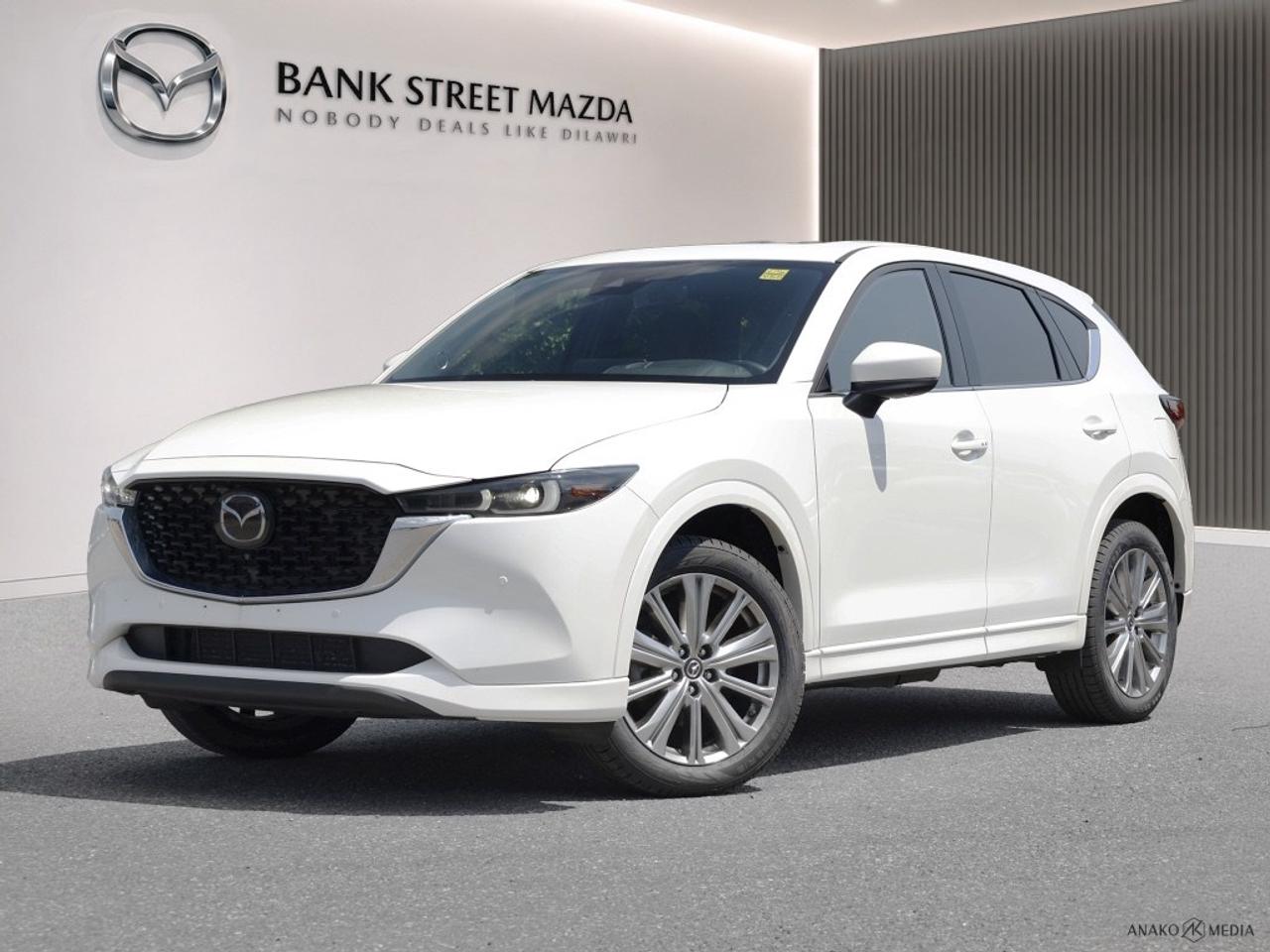 The 2022 Mazda CX-5 Signature AWD in a sophisticated hue combines refined styling with exceptional all-wheel-drive handling. This SUV is perfect for those seeking both performance and elegance. Externally, the alloy wheels complement the sleek design, while inside, luxury is redefined with leather seats and a leather-wrapped steering wheel that ensure maximum comfort. The Signature trim boasts an elegant interior with a thoughtful design that includes cooled front seats and heated rear seats, perfect for the Canadian climate. Embrace cutting-edge technology with features like the heads-up display and a comprehensive navigation system to guide every journey. Safety is enhanced with brake assist, lane assist, and parking sensors, ensuring peace of mind behind the wheel. Smart device integration and a sunroof/moonroof offer enjoyment and connectivity, enhancing every drive. This vehicle is ideal for discerning drivers who value a blend of technology, luxury, and safety in their drive. Contact Bank Street Mazda today to experience the mastery of the Mazda CX-5 and make it yours.