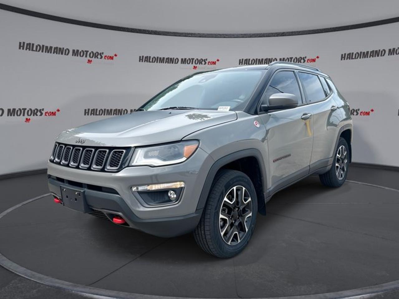 // ACCIDENT FREE!! //<br />// SINGLE OWNER! //<br /><br />This 2021 Jeep Compass Trailhawk Elite 4x4 is a well-equipped compact SUV built for Canadian roads, changing weather, and daily comfort. Finished in Grey with a Black interior, it offers rugged Jeep capability, a smooth automatic transmission, and a confident 4WD system. With only 41,757 km, this accident-free, single-owner Compass Trailhawk Elite 4x4 delivers strong value and proven versatility.<br /><br />Designed with four doors and practical SUV space, this 2021 Jeep Compass Trailhawk Elite 4x4 blends trail-ready character with upscale features drivers use every day. The 2.4-litre gas engine gives dependable power for commuting, highway travel, and weekend trips, while premium touches like ventilated front seats and a panoramic sunroof add comfort in every season.<br /><br />FEATURES OF THE Compass Trailhawk Elite 4x4 | One Owner | No Accidents | Vent. Front Seats<br />   Ventilated front seats add summer comfort<br />   Panoramic sunroof brightens every drive<br />   Four-wheel drive boosts all-weather confidence<br />   Navigation system helps guide every trip<br /><br />ADVANCED SAFETY FEATURES<br />   Blind spot monitor supports safer lane changes<br />   Backup camera helps with reversing confidence<br />   Stability control enhances handling on slick roads<br />   Multiple airbags provide added occupant protection<br /><br />PERFORMANCE AND EFFICIENCY<br />   2.4-litre gas engine balances power efficiently<br />   Automatic transmission delivers smooth daily driving<br />   Four-wheel drive improves traction year-round<br />   Dual shift mode adds driving control<br /><br />COMFORT AND CONVENIENCE<br />   Ventilated front seats improve warm-weather comfort<br />   Heated front seats warm cold mornings<br />   Heated steering wheel feels great in winter<br />   Remote starter adds everyday convenience<br /><br />TECHNONOLGY AND CONNECTIVITY<br />   Apple CarPlay keeps apps within reach<br />   Android Auto supports simple smartphone integration<br />   Bluetooth integration allows hands-free communication<br />   Navigation system helps simplify unfamiliar routes<br /><br />CARGO SPACE<br />   Rear trunk access makes loading easier<br />   Four-door layout supports family practicality<br />   Flexible cargo area suits daily errands<br />   Spare tire adds travel peace of mind<br /><br />AWARDS & RECOGNITIONS<br />   Top Safety Pick, Insurance Institute for Highway Safety, 2021<br /><br />WHAT OTHER OWNERS LIKE<br />   Confident four-wheel drive in poor weather<br />   Comfortable ride for commuting and travel<br />   Easy-to-use infotainment and phone connectivity<br />   Useful size for city and highway<br /><br />This 2021 Jeep Compass Trailhawk Elite 4x4 stands out with the features drivers want most. Adaptive cruise control helps reduce stress on longer drives. Dual-zone automatic climate control lets front passengers choose their ideal temperature. Heated mirrors, power windows, power steering, and push button start all add ease to every trip.<br /><br />This 2021 Jeep Compass Trailhawk Elite 4x4 also brings a refined cabin feel with memory seating, a power drivers seat, power passenger seat, leather-wrapped steering wheel, steering wheel audio controls, and ambient lighting. Automatic headlights, fog lights, tinted windows, and turn signal mirrors add useful function and a polished appearance without giving up the rugged Jeep personality.<br /><br />For drivers who need utility, this 2021 Jeep Compass Trailhawk Elite 4x4 includes a rear spoiler, rear tow hook, and trailer hitch for added versatility. Whether you are driving through Cayuga, heading out on the highway, or managing winter roads, this SUV is ready with comfort, traction, and smart technology in one capable package.<br /><br />This 2021 Jeep Compass Trailhawk Elite 4x4 | One Owner | No Accidents | Vent. Front Seatss VIN is: 3C4NJDDB6MT597833 .<br /><br />WHY CHOOSE US? <br /><br />Honest & Transparent Buying Experience: Weve been a trusted name in business since 1984.<br /><br />STRAIGHTFORWARD PRICING:<br />Our Advertised Price Includes:<br />>>Safety Certification (No separate fee!)<br />>>30-Day 100% Mechanical Warranty<br />>>FREE Carfax History Report.<br />>>No upcharge for paying cash.<br />(Prices Exclude HST and Licensing Fees only.)<br /><br />>>Browse 300+ vehicles all in ONE LOCATION<br /><br />EASY FINANCING: Great rates & open loans<br /><br />WE BUY CARS: Get Top Dollar for your trade-in, or sell us your vehicle for CASH! Even if you dont buy from us!<br /><br />STOP BY TODAY<br />Treat yourself - stop by Haldimand Motors Ltd. located at 42 Talbot St E, Cayuga, ON N0A 1E0 to make this car yours today!<br /><br />https://www.haldimandmotors.com/used/stock-465163.html