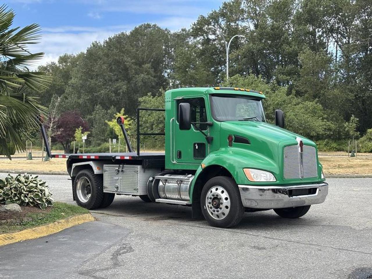This 2013 Kenworth T370 Roll-Off Hook Truck is powered by a 6.7L 6-cylinder diesel engine paired with an Allison automatic transmission and rear-wheel drive. Designed for commercial hauling, waste management, construction, and municipal applications, this truck is equipped with a hydraulic roll-off hook system for loading and transporting compatible containers and bodies.

The truck features a flat deck measuring approximately 10 feet 9 inches long by 8 feet 4.5 inches wide, providing a stable platform for roll-off operations. Additional equipment includes a trailer brake controller, air conditioning and heat, power windows, and power door locks for operator convenience.

Finished in green with a beige cloth interior, this Kenworth T370 offers a practical roll-off truck platform suitable for container transport, equipment hauling, and a variety of commercial fleet applications. This item is currently OFFSITE. You must register an appointment with our office to schedule an offsite viewing. Appointments must be made a minimum of one business day in advance (and as defined by the days that Repo.com is open for business) before your appointment can be scheduled and confirmed. We may, at our own discretion, instead opt to transport smaller items to Repo.coms main yard for viewing purposes.  $88,870.00 plus $375 processing fee, $89,245.00 total payment obligation before taxes.   Listing report, warranty, contract commitment cancellation fee, financing available on approved credit (some limitations and exceptions may apply). All above specifications and information is considered to be accurate but is not guaranteed and no opinion or advice is given as to whether this item should be purchased. We do not allow test drives due to theft, fraud, acts of vandalism and undetectable impaired driving. Instead we provide the following benefits: Complimentary Warranty (with options to extend), Limited Money Back Satisfaction Guarantee on Fully Completed Contracts, Contract Commitment Cancellation, and an Open-Ended Sell-Back Option. Ask seller for details or call 604-522-REPO(7376) to confirm listing availability.