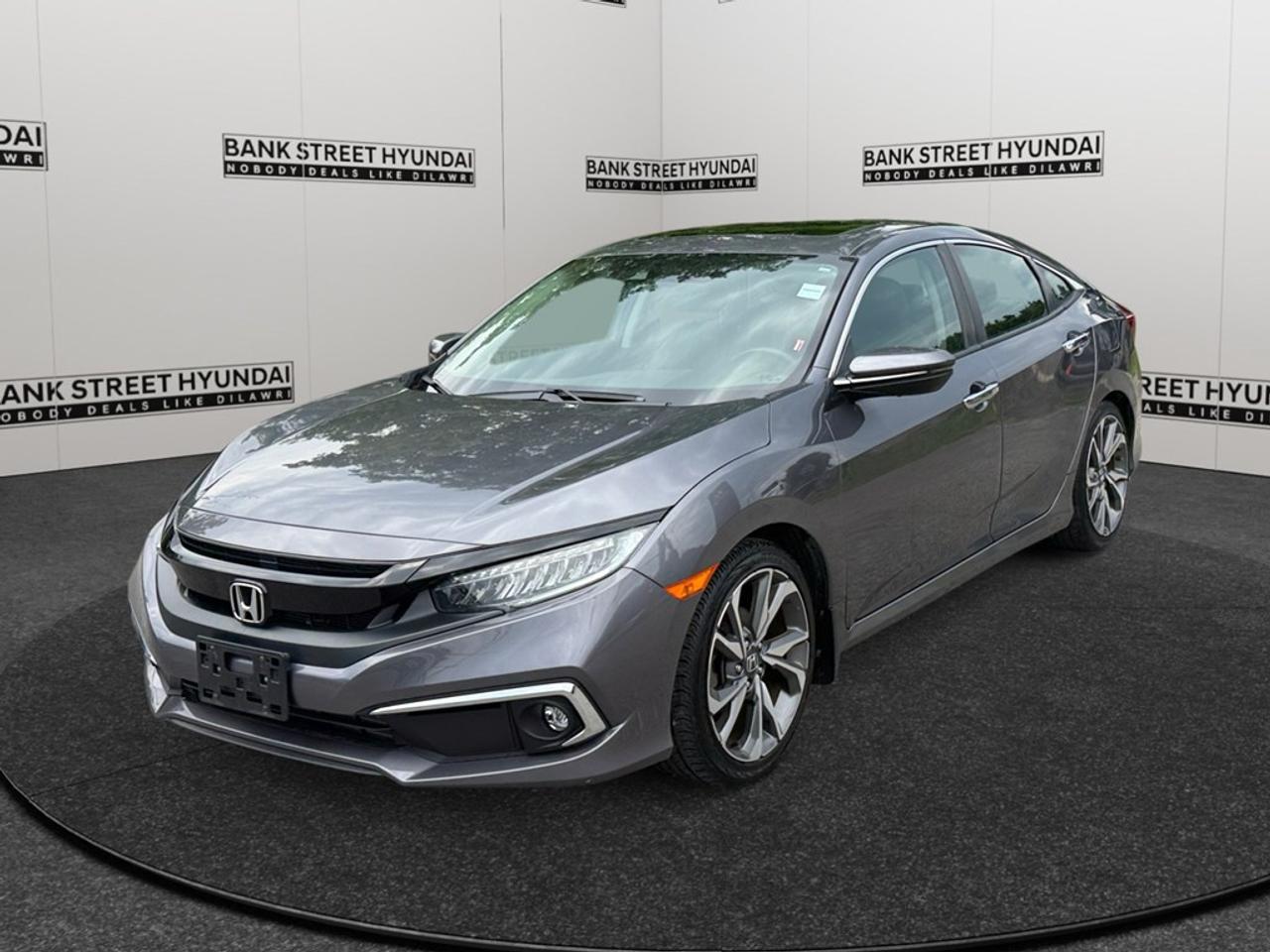 Step into the elegant world of the 2019 Honda Civic Sedan Touring in a striking shade that complements its stylish design. Powered with an efficient FWD drivetrain and a seamless automatic transmission, this sedan offers impeccable handling and control. This Civic Sedan Touring boasts a refined exterior equipped with alloy wheels, a sunroof for those sunny days, and heated mirrors to get you through the Canadian winters. Inside, youll find a luxurious atmosphere with leather seats, leather steering wheel, and leatherette door trim inserts. The comfort doesnt stop thereit also comes with heated front and rear seats, making every journey a pleasant one. Tech-savvy drivers will appreciate the integration of advanced technology, including a navigation system, smart device integration, and satellite radio. Safety and driver assistance features such as lane assist, a backup camera, brake assist, and adaptive cruise control are also part of this impressive package. Perfect for families or daily commuters looking for a reliable and feature-packed vehicle, the 2019 Honda Civic Sedan Touring is an ideal choice. Dont miss this opportunitycontact Bank Street Hyundai today to learn more and take it for a spin!
