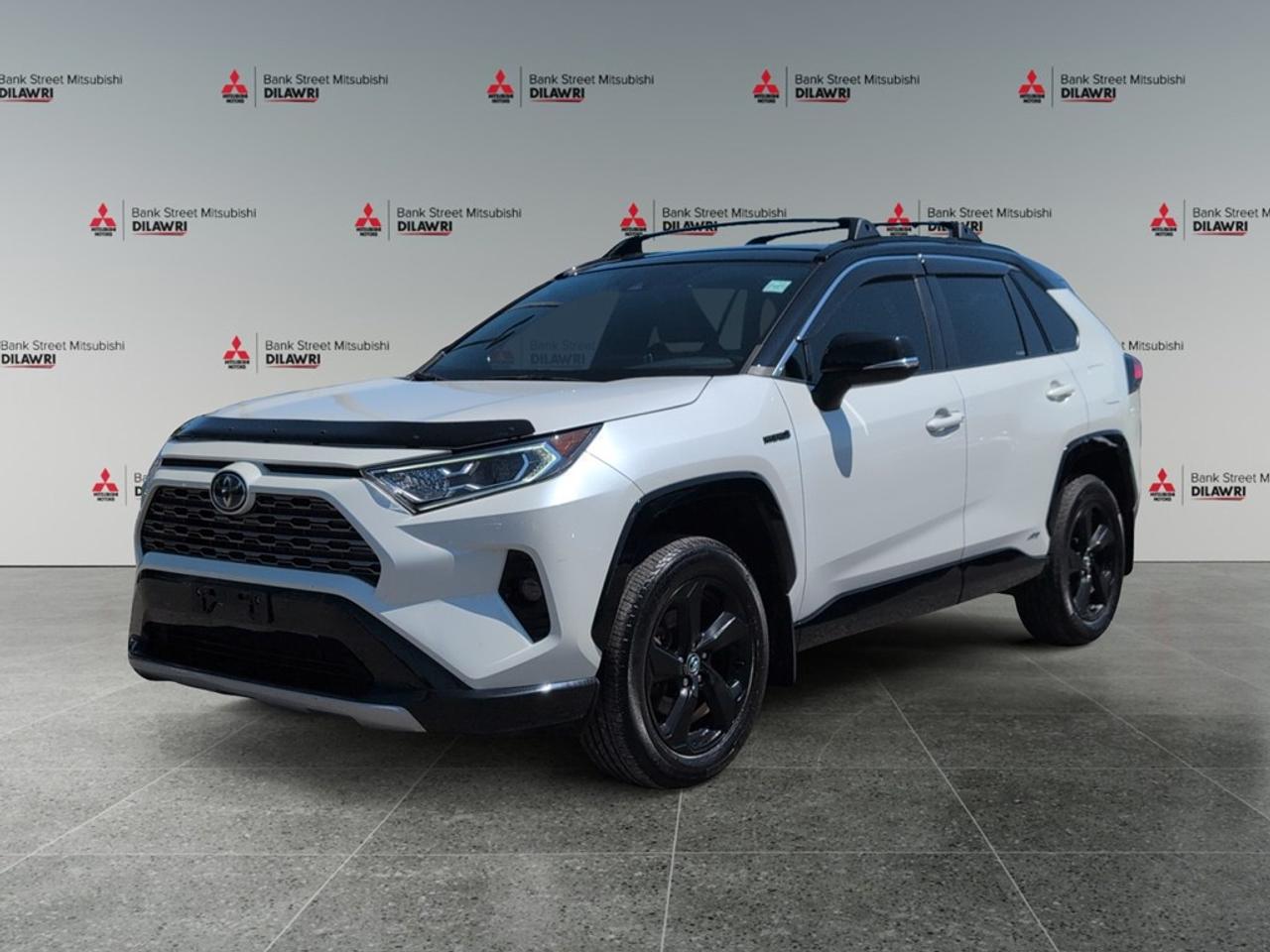 Balance of 5 year/100,000kms BASIC warranty and 10 year/160,000kms Factory Powertrain Warranty on ALL MITSUBISHI products! Best in the industry!!!! Experience the exquisite blend of style and performance with the 2021 Toyota RAV4 HYBRID XSE AWD in a stunning white finish. This SUV offers impressive handling and stability thanks to its all-wheel drive system, making it the ideal choice for every journey, whether on bustling city streets or adventurous trails. The exterior of the RAV4 captures attention with its modern design, highlighted by sleek alloy wheels. Step inside the spacious interior where heated seats provide comfort no matter the season, and the expansive cabin is designed for both driver and passenger convenience. Equipped with cutting-edge technology, this vehicle features smart device integration and a user-friendly backup camera, enhancing both connectivity and confidence while on the road. Advanced safety features like lane assist and brake assist ensure peace of mind, making every drive enjoyable and secure. Whether youre a family seeking an adventurous ride or an individual looking for a versatile vehicle, the 2021 Toyota RAV4 HYBRID XSE AWD is your perfect match. Contact Bank Street Mitsubishi today for more information and schedule a test drive to feel the excellence firsthand.