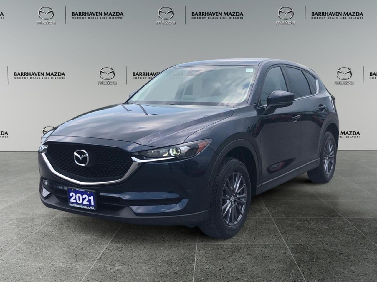 The 2021 Mazda CX-5 GX, in a striking blue finish and equipped with front-wheel drive, offers nimble handling perfect for bustling city driving and weekend adventures. This stylish SUV showcases a modern design that perfectly balances elegance with functionality. The sleek exterior is complemented by alloy wheels and heated mirrors, emphasizing both style and substance. Step inside and experience the comfort of heated front seats, with generous space that accommodates all your needs. Stay connected and safe with cutting-edge technology including a backup camera, Bluetooth connection, and smart device integration. The vehicle is also equipped with essential safety features like lane assist and brake assist, while the option of a keyless entry provides unmatched convenience. This CX-5 is an ideal choice for individuals and families who value comfort, safety, and the latest technology. Reach out to Barrhaven Mazda for more information and let us help you drive away in this fantastic SUV today!