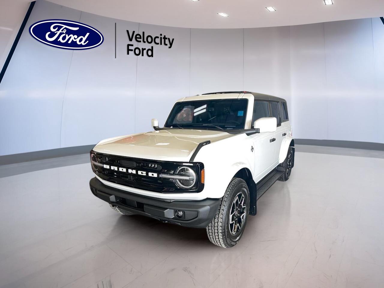 Brand new and built for adventure, the 2026 Ford Bronco Outer Banks 4 Door 4x4 brings open-air freedom, everyday comfort, and real 4x4 capability to Moose Jaw. Finished in White with a Black interior, this four-door SUV pairs a 2.7-litre unleaded engine with an automatic transmission for confident driving on pavement and beyond.

This 2026 Ford Bronco Outer Banks 4 Door 4x4 stands out with its removable convertible roof design, bold off-road-ready stance, and practical features for daily use. It offers a refined balance of rugged utility and modern convenience, making it a smart choice for drivers who want style, space, and true all-terrain confidence.

FEATURES OF THE Bronco Outer Banks 4 Door 4x4
»» Four-door body with open-air capability
»» 2.7-litre engine with automatic transmission
»» Four-wheel drive for added traction
»» White exterior with Black interior

ADVANCED SAFETY FEATURES
»» Backup camera helps with reversing visibility
»» Blind spot monitor adds lane awareness
»» Lane departure warning supports safer travel
»» Multiple airbags enhance occupant protection

PERFORMANCE AND EFFICIENCY
»» 2.7-litre unleaded engine delivers strong power
»» Automatic transmission supports smooth shifting
»» Four-wheel drive improves off-road control
»» Off-road tires boost trail-ready traction

COMFORT AND CONVENIENCE
»» Heated front seats add cold-weather comfort
»» Dual-zone climate control helps cabin comfort
»» Remote starter adds everyday convenience
»» Power windows simplify daily operation

TECHNOLOGY AND CONNECTIVITY
»» Navigation system helps guide each trip
»» Bluetooth integration supports hands-free calling
»» WiFi hotspot keeps devices connected
»» Steering wheel audio controls aid access

CARGO SPACE
»» Rear trunk access eases cargo loading
»» Four-door layout helps passenger entry
»» Spare tire adds travel reassurance
»» Cabin storage supports daily practicality

WHAT OTHER OWNERS LIKE
»» Confident four-wheel drive in tough conditions
»» Easy open-air driving experience and fun
»» Strong engine performance for daily use
»» Useful tech for modern connected driving

This Ford SUV also includes practical features that drivers value every day. Cruise control, power steering, anti-lock braking system, stability control, child safety locks, heated mirrors, electric mirrors, automatic headlights, fog lights, tinted windows, push button start, and automatic door locks all help make each drive easier and more secure.

Inside, this 2026 Ford Bronco Outer Banks 4 Door 4x4 offers a welcoming cabin with front air conditioning, automatic climate control, drivers seat lumbar support, power drivers seat, power passenger seat, ambient lighting package, illuminated vanity mirrors, an auto-dimming rearview mirror, and a leather-wrapped steering wheel. It is well equipped for comfort in every season.

Sold by Velocity Ford in Moose Jaw, this brand new 2026 Ford Bronco Outer Banks 4 Door 4x4 is ready for work, weekends, and everything in between. With its capable 4WD system, convertible design, advanced safety features, and connected technology, it delivers the versatility many SUV shoppers want in one confident package.

This 2026 Ford Bronco Outer Banks 4 Door 4x4s VIN is: 1FMEE8BPXTLB20113.