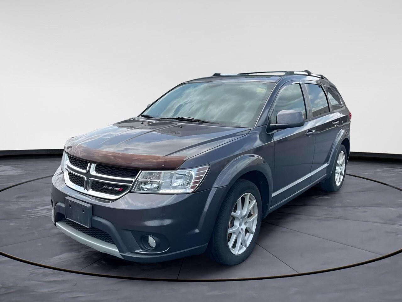 Experience the perfect blend of performance and style with the 2014 Dodge Journey Limited, clad in a sophisticated gray. This SUV features a smooth front-wheel drive with agile handling for urban and highway journeys alike. Built with a robust 3.6L V6 engine paired with a 6-speed automatic transmission, it offers a reliable and engaging drive every time you hit the road.

The exterior showcases bright side roof rails and Limited badge, proudly marking its identity. Inside, you are welcomed by a spacious and luxurious cabin, complete with heated front seats and a leather steering wheel for a touch of elegance. With power seats, power windows, and a universal garage door opener, your comfort and convenience are fully addressed.

Embrace modern technology with an 8.4" touch screen display equipped with Sirius Satellite Radio for endless entertainment options. Safety is prioritized with brake assist and heated mirrors, while driver assistance features like cruise control make long drives effortless and enjoyable.

Ideal for families and adventure enthusiasts, the 2014 Dodge Journey Limited offers a perfect mix of comfort, technology, and functionality. Reach out to Windsor Chrysler today for more information and to schedule a test drive to see what makes this vehicle the perfect choice for your needs.