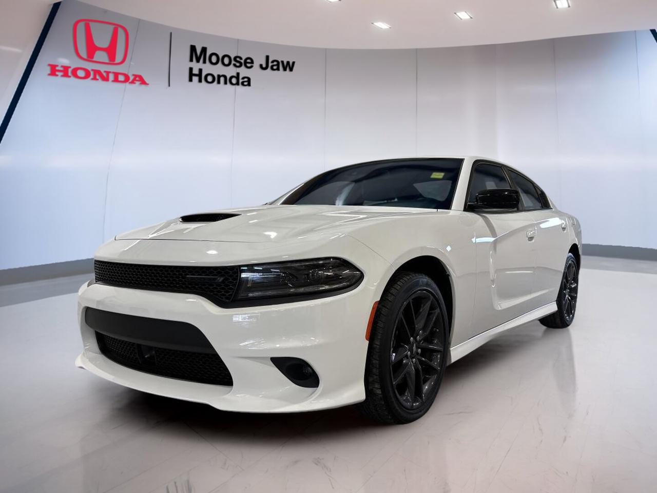 The 2023 Dodge Charger GT brings bold sedan style, strong V6 power, and everyday comfort together in one confident package. Finished in White and equipped with an automatic transmission, this used Charger GT at Moose Jaw Honda in Moose Jaw has 45,521 km on the odometer and delivers the classic full-size Dodge experience drivers want.

This 2023 Dodge Charger GT stands out with its wide stance, four-door practicality, and performance-focused character. It offers the space of a sedan with the attitude of a muscle car-inspired design. For drivers who want comfort, road presence, and smooth power, this Charger GT makes a smart choice.

FEATURES OF THE Charger GT

»» Bold four-door performance sedan design
»» V6 power with smooth automatic shifting
»» Rear-wheel-drive character and balanced handling
»» Sport-inspired appearance with practical cabin

ADVANCED SAFETY FEATURES

»» Rearview camera supports easier reversing
»» Advanced airbag system enhances occupant protection
»» Electronic stability control helps maintain traction
»» Anti-lock braking system supports controlled stops

PERFORMANCE AND EFFICIENCY

»» 3.6-litre Pentastar V6 delivers strong response
»» Automatic transmission provides smooth daily driving
»» Rear-wheel-drive layout supports balanced road feel
»» Efficient highway cruising for full-size sedan

COMFORT AND CONVENIENCE

»» Spacious cabin with comfortable seating layout
»» Four-door access adds daily practicality
»» Dual-zone climate control improves cabin comfort
»» Large interior suits passengers and gear

TECHNOLOGY AND CONNECTIVITY

»» Touchscreen interface keeps controls simple
»» Bluetooth connectivity supports hands-free communication
»» USB ports help keep devices charged
»» Steering wheel controls aid easy access

CARGO SPACE

»» Large trunk suits everyday cargo needs
»» Wide opening helps load bulky items
»» Rear seat flexibility supports extra utility
»» Sedan practicality fits travel or errands

AWARDS & RECOGNITIONS

»» Top-rated infotainment usability, AutoPacific Vehicle Satisfaction Awards, 2023

WHAT OTHER OWNERS LIKE

»» Strong V6 performance for daily driving
»» Comfortable ride on city streets
»» Spacious cabin for family use
»» Bold styling with classic Dodge attitude

The 2023 Dodge Charger GT remains a popular choice for drivers who want more than basic transportation. Its roomy interior, confident road manners, and proven V6 performance make it well suited for commuting, highway travel, and weekend drives alike. The automatic transmission keeps every trip smooth and easy.

For shoppers in Moose Jaw looking for a used sedan with personality, this 2023 Dodge Charger GT offers a rare mix of comfort, presence, and practicality. The White exterior adds a clean, sharp look, while the overall design keeps the car modern and athletic. With 45,521 km, this Charger GT is ready for many more kilometres ahead.

This 2023 Dodge Charger GTs VIN is: 2C3CDXMG1PH525127 .