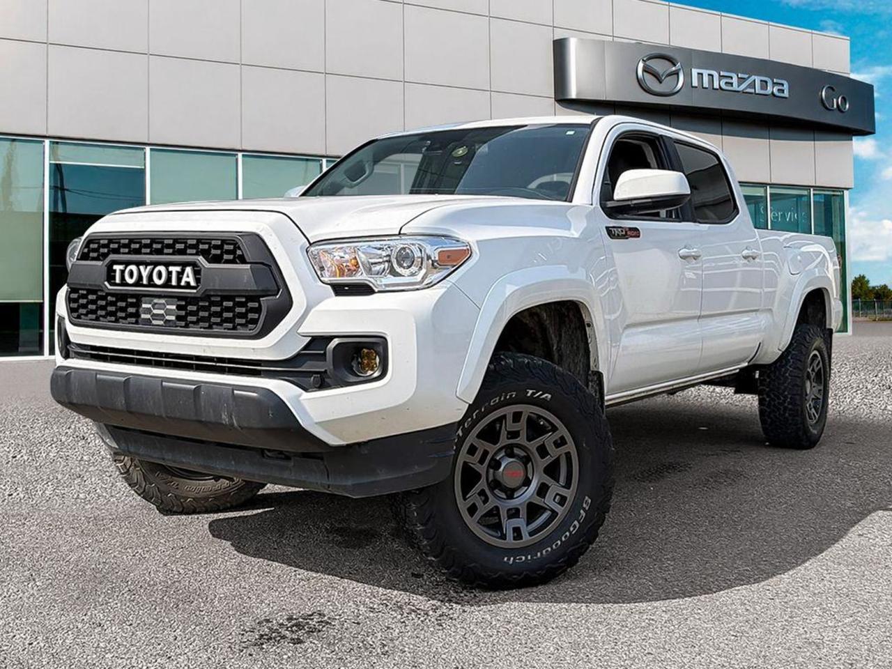 **2021 ToyotaTacoma4×4 Double Cab  PreOwned, Ready for Anything**Built for work and play, this Tacoma delivers the legendary Toyota toughness you expect, now with a premium set of comfort and tech upgrades. Dressed in crisp SuperWhite and backed by a 3.5L DirectInjection V6 (278hp) paired to a smooth 6speed automatic, its the perfect blend of power, efficiency and confidenceintheroad.**Why this Tacoma stands out**- **Allterrain capability**  Parttime 4WD, electronic transfercase shift, hillstart assist, brakeactuated limitedslip differential and a ClassIV tow rating make light work of trails, work sites, and weekend getaways. - **Comfort for you and passengers**  Heated front bucket seats, heated driver and passengerside mirrors, 60/40 folding rear bench, and a fullyloaded interior (metallook accents, leatherette shifter boot, illuminated entry, and a primarymonitor touchscreen with Uconnectstyle connectivity). - **Safety & confidence**  8airbag suite, vehiclestability control, allspeed ABS, traction control, lanedeparture prevention, forwardcollision mitigation, pedestrianimpact mitigation, and driverattention alert keep you protected in every drive. - **Convenient tech**  Digital rearview mirror, voiceactivated audio, wireless device streaming, cruisecontrol with steeringwheel buttons, and a rearview camera for easy maneuvering in tight spots. - **Rugged convenience**  Fullsize spare with steel wheel, underbody skid plate, splash guards, bodycoloured bumpers and fender flares, lockup transmission, and a sturdy steelwheel pickup box with integrated storage and a trifold tonneau cover.**In a nutshell:** A SuperWhite 2021 Tacoma that combines a capable V6 powertrain, premium heatedseat comfort, comprehensive safety tech, and genuine Toyota durabilityall at a price that makes stepping into a true offroad workhorse affordable.Swing by the showroom today, take it for a spin, and see why the Tacoma remains the goto midsize pickup for adventurers and professionals alike.Go Mazda is an AMVIC licensed business.