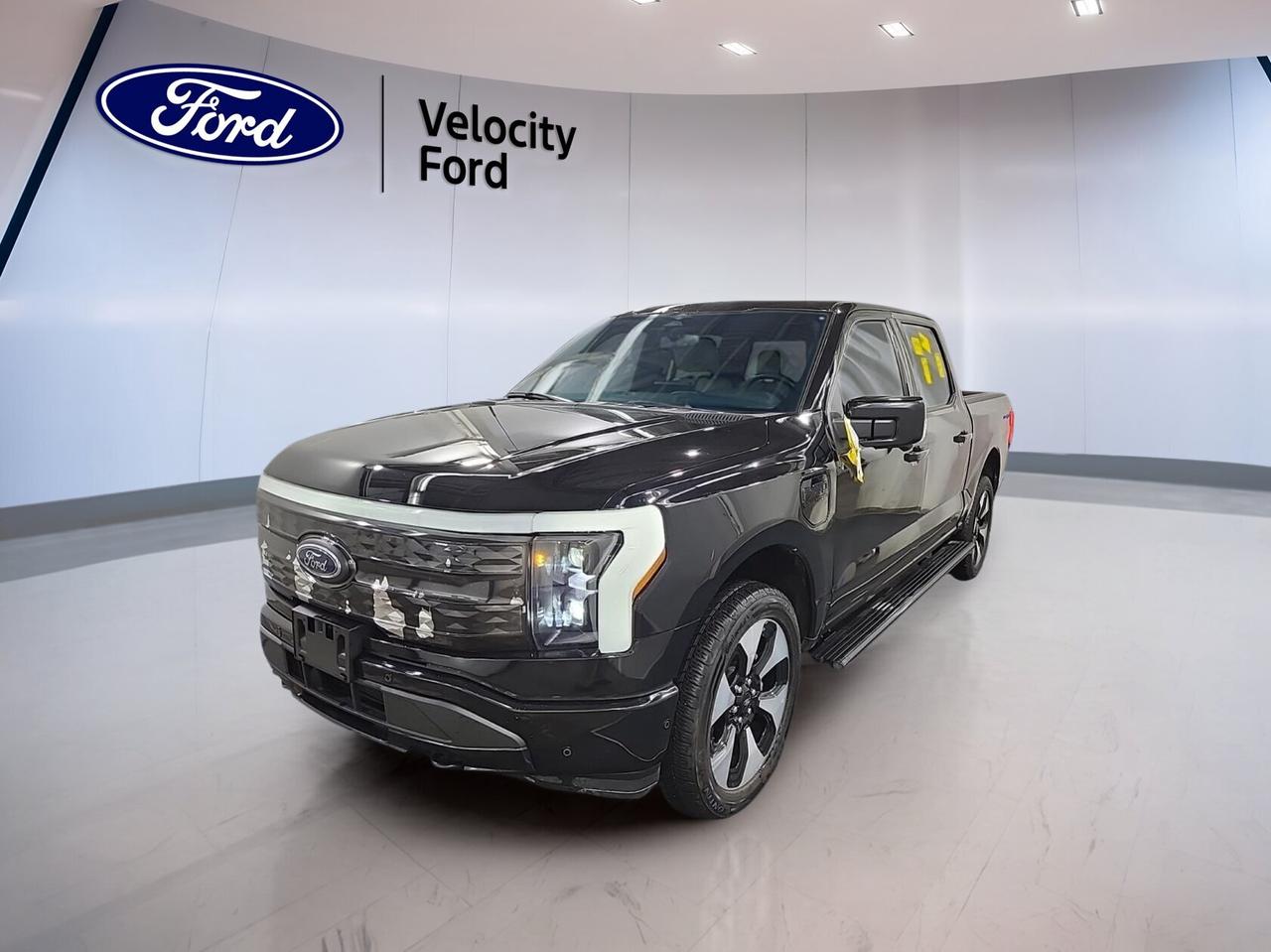 Discover fully electric power and premium comfort in this used 2023 Ford F-150 Lightning Platinum 4WD SuperCrew 5.5 Box at Velocity Ford in Moose Jaw. Finished in Black with a Black interior, this four-door pickup blends advanced tech, strong towing ability, and everyday ease. With 126,271 km, it is ready to keep working.

As a fully electric truck, this 2023 Ford F-150 Lightning Platinum 4WD SuperCrew 5.5 Box delivers quiet performance, instant torque, and impressive range for daily driving or longer trips. Its automatic transmission helps provide smooth power delivery, while the Platinum trim adds upscale features that make every drive feel refined.

FEATURES OF THE F-150 Lightning Platinum 4WD SuperCrew 5.5 Box
»» Fully electric pickup with premium Platinum trim
»» SuperCrew cab with four full doors
»» Black exterior with matching Black interior
»» Panoramic sunroof adds open, airy feel

TRUCK FEATURES
»» Tows up to 3,492 kg confidently
»» Rear tow hook supports truck utility
»» Side steps ease cabin entry
»» SuperCrew cab adds passenger versatility

ELECTRIC VEHICLE FEATURES
»» Fully electric driving with impressive range
»» Instant torque for quick, smooth response
»» Quiet operation with no fuel stops
»» Lower routine maintenance than gas trucks

ADVANCED SAFETY FEATURES
»» Backup camera helps with reversing views
»» Lane departure warning adds driving support
»» Blind spot monitor boosts lane awareness
»» Stability control helps maintain traction

PERFORMANCE AND EFFICIENCY
»» Automatic transmission delivers smooth power response
»» Limited slip differential aids traction
»» Performance tires support confident road grip
»» Electric power means zero tailpipe emissions

COMFORT AND CONVENIENCE
»» Heated front and rear seats included
»» Dual-zone climate control adds comfort
»» Memory seats simplify shared driving setups
»» Adjustable pedals improve driving position

TECHNOLOGY AND CONNECTIVITY
»» Navigation system guides every trip clearly
»» Bluetooth integration supports hands-free calling
»» Wi-Fi hotspot keeps devices connected
»» Steering wheel audio controls add ease

CARGO SPACE
»» Rear trunk access adds storage flexibility
»» Four-door layout helps load passengers easily
»» Power windows add daily convenience
»» Spare tire supports added peace of mind

AWARDS & RECOGNITIONS
»» North American Truck of the Year, North American Car, Truck and Utility Vehicle of the Year, 2023
»» Best Electric Truck, AutoTrader, 2023

WHAT OTHER OWNERS LIKE
»» Strong electric acceleration from every stop
»» Quiet ride with premium cabin comfort
»» User-friendly technology and large screens
»» Useful towing ability for daily tasks

This fully electric 2023 Ford F-150 Lightning Platinum 4WD SuperCrew 5.5 Box stands out with premium comfort, practical truck capability, and advanced connectivity. Heated mirrors, retractable mirrors, LED headlamps, tinted windows, push button start, satellite radio, HD Radio, and automatic headlights all add value to your day.

If you want a fully electric truck that feels modern, capable, and well-equipped, this 2023 Ford F-150 Lightning Platinum 4WD SuperCrew 5.5 Box is a smart choice at Velocity Ford in Moose Jaw. It delivers premium features, useful towing strength, and the confidence of electric performance in one impressive package.

This 2023 Ford F-150 Lightning Platinum 4WD SuperCrew 5.5 Boxs VIN is: 1FT6W1EV6PWG03769.