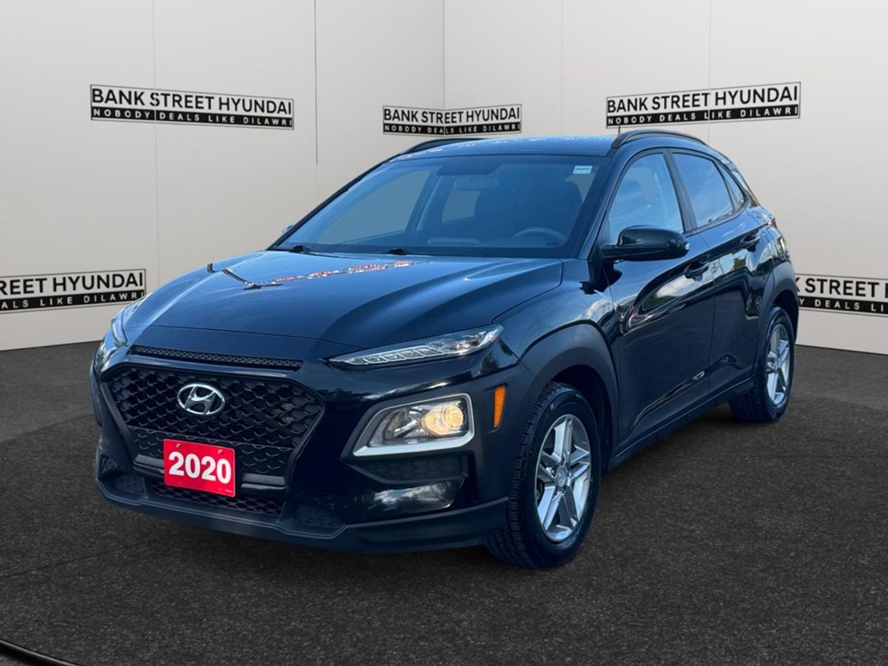 The 2020 Hyundai Kona Essential in black with an AWD drivetrain and an automatic transmission delivers responsive handling, making it perfect for both urban adventures and rural explorations. The sleek black exterior gives the Kona a refined and bold presence on the road while the sophisticated interior offers comfort and style. With premium features like air conditioning, alloy wheels, and keyless entry, every journey becomes more enjoyable. The spacious and well-appointed cabin invites you to sit back and enjoy the ride, especially with the addition of heated seats for those chilly Canadian mornings. Technologically, the Kona is equipped to keep you connected and secure. It includes a backup camera and smart device integration, ensuring both convenience and safety. Advanced features like brake assist and heated mirrors further extend the safety net, ensuring peace of mind wherever you go. This SUV is ideal for active families or individuals who need versatility and dependable performance across varied terrains. Contact Bank Street Hyundai today to learn more about how the Hyundai Kona can enhance your driving experience.