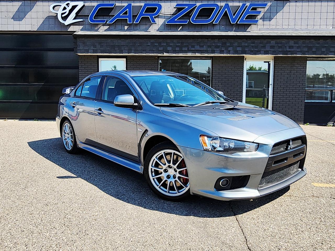 <p class=isSelectedEnd>Experience one of Mitsubishi&rsquo;s most iconic performance cars. Finished in <strong>Apex Silver Metallic with a black interior</strong>, this Evo GSR combines legendary AWD performance with an engaging manual transmission.</p><h3>Key Highlights</h3><ul data-spread=false><li><strong>114,920 km</strong></li><li><strong>Manual Transmission</strong></li><li><strong>2.0L Turbocharged Engine</strong></li><li><strong>S-AWC All-Wheel Drive</strong></li><li><strong>One Owner &ndash; Purchased New in 2013</strong></li><li><strong>No Accidents</strong></li><li><strong>Owned Outright &ndash; No Liens</strong></li><li><strong>Original Engine, Transmission & Clutch</strong></li><li><strong>No Current Tune</strong></li><li><strong>Two Keys</strong></li><li><strong>Mostly Dealership Serviced</strong></li><li><strong>Most Service Records Available</strong></li><li>Primarily stored in a <strong>heated underground parkade</strong></li></ul><h3>Service & Maintenance</h3><ul data-spread=false><li>Major service completed around <strong>80,000 km</strong>, including full brake service</li><li>Inner & outer tie rods replaced at <strong>98,289 km</strong></li><li><strong>AYC pump replaced under warranty in 2022</strong></li><li><strong>Optima YellowTop battery installed in 2025</strong></li><li>Tires approximately <strong>5/32&ndash;6/32</strong></li></ul><h3>Upgrades</h3><ul data-spread=false><li><strong>Pioneer touchscreen with Apple CarPlay</strong></li><li><strong>Compustar two-way remote starter/alarm</strong></li><li>DroneMobile with <strong>GPS tracking</strong></li><li><strong>BlackVue front & rear dash cameras</strong></li><li>K&N cold-air intake</li><li>K&N upper intercooler hard pipe</li><li>Carbon-fibre hood scoop</li><li>Megan Racing test pipe</li><li>Cobb Accessport V3 available but <strong>never installed</strong></li><li>Several <strong>original factory parts included/available</strong></li></ul><p>A well-documented, <strong>one-owner Evo GSR</strong> with the original drivetrain, manual transmission, no current tune, strong service history, and tasteful upgrades&mdash;an increasingly hard-to-find combination for an Evolution.</p><p>Looking for Your Dream Car? Call Car Zone Today!</p><p>Thanks for viewing our Car Zone inventory. All of our vehicles come fully detailed with a Carfax and a mechanical fitness assessment. Drive this home today! Easy financing options. All credit welcome.&nbsp;<strong><a href=http://www.carzonecalgary.ca/finance>APPLY NOW</a>&nbsp;</strong>We even take trades. Same day approvals at&nbsp;<a href=http://www.carzonecalgary.ca/><strong>CARZONECALGARY</strong></a> or visit us in person at 2036 36 Street SE Calgary for a hassle free test drive. Let our friendly team of experts book an appointment with you and show you the Car Zone difference! AMVIC licensed dealer.&nbsp;</p>