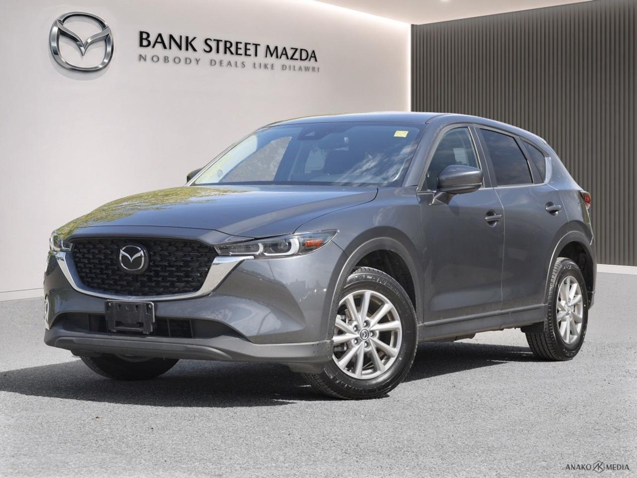 The 2023 Mazda CX-5 GS AWD, presented in a refined gray, offers a dynamic driving experience with its all-wheel-drive system and smooth automatic transmission. This SUV embodies a perfect blend of versatility and sophistication. Step into a world where comfort meets style. The CX-5 features luxurious alloy wheels and practical heated seats, ensuring a pleasant journey in any weather. The exterior gray finish adds a touch of elegance while the smartly designed body speaks to Mazdas commitment to quality and performance. Technology enthusiasts will appreciate the Bluetooth connection and smart device integration, keeping you connected on the go. Safety is paramount with advanced features like the backup camera and lane assist ensuring peace of mind for you and your family. The brake assist enhances control, while keyless entry and power seats add convenience to every drive. Ideal for those seeking a reliable family vehicle or an adventurous solo ride, this 2023 Mazda CX-5 GS AWD is waiting for you at Bank Street Mazda. Experience it yourself and discover why its the right choice for your lifestyle. Contact us today to learn more!